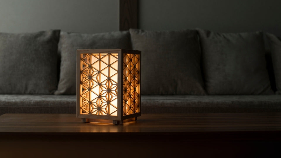Japanese kumiko table lamp emits beautiful shadow and warm glow on a Living room table.