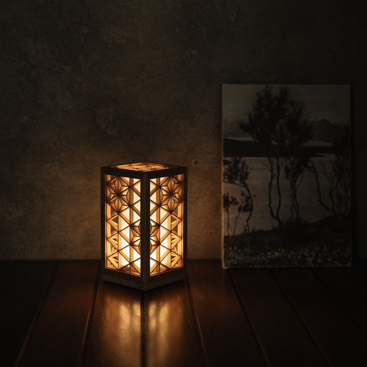 "Lampe de table japonaise Kumiko « Asanoha » sur une table de salon avec un livre."