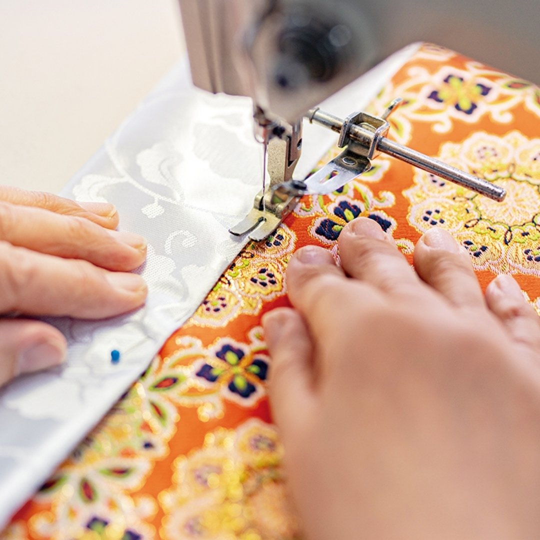 Sakae Kinran artisan sewing red kinran fabric