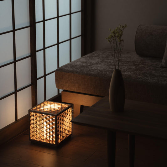 Japanese floor lamp, meticulously handcrafted with 600 pieces of premium Akita cedar using the traditional "kumiko" woodworking technique, illuminating a Japanese-style living room with low-rise furniture and a shoji screen.
