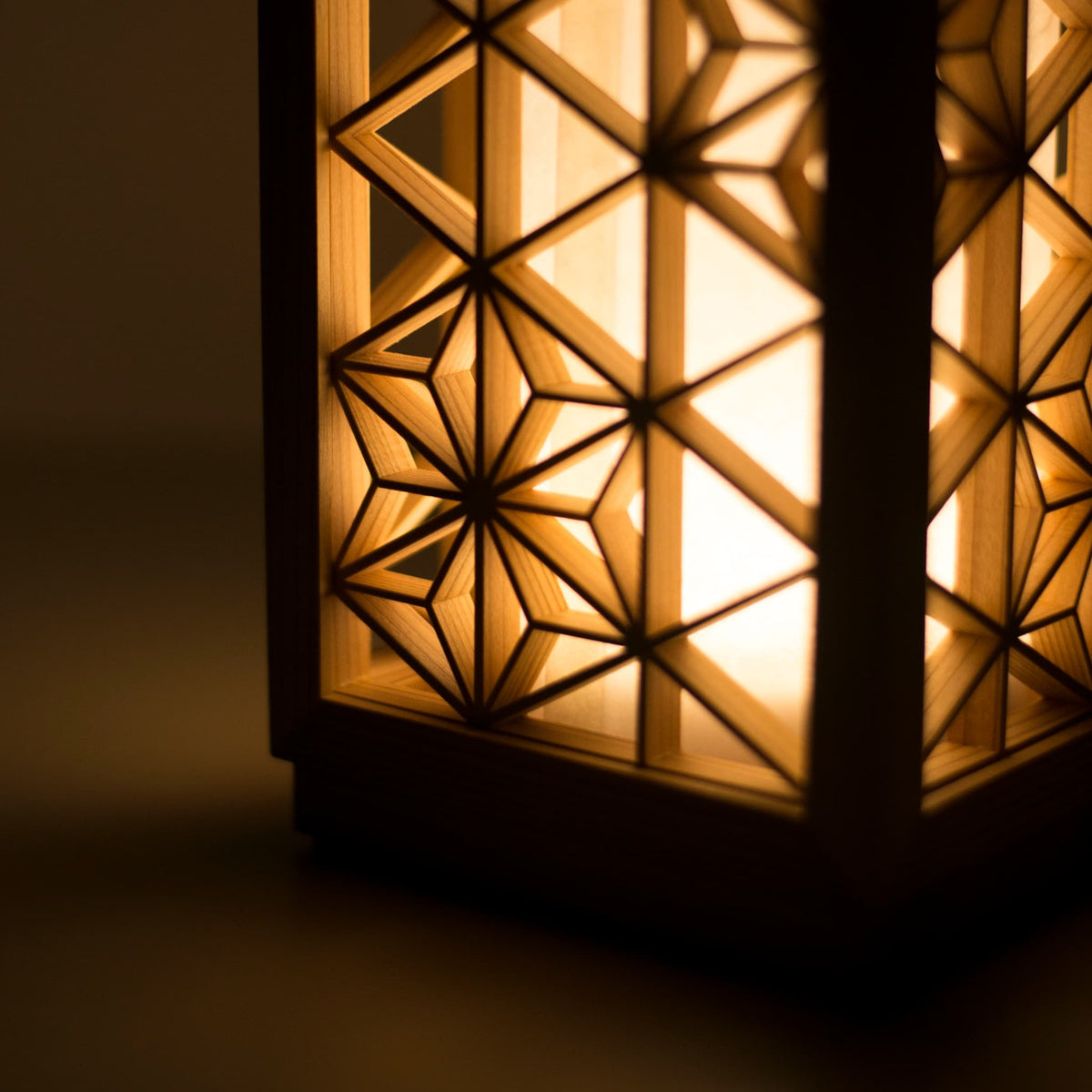 Une lampe de table utilisant le kumiko, une technique japonaise traditionnelle d'assemblage de petites pièces de bois pour créer des motifs géométriques.