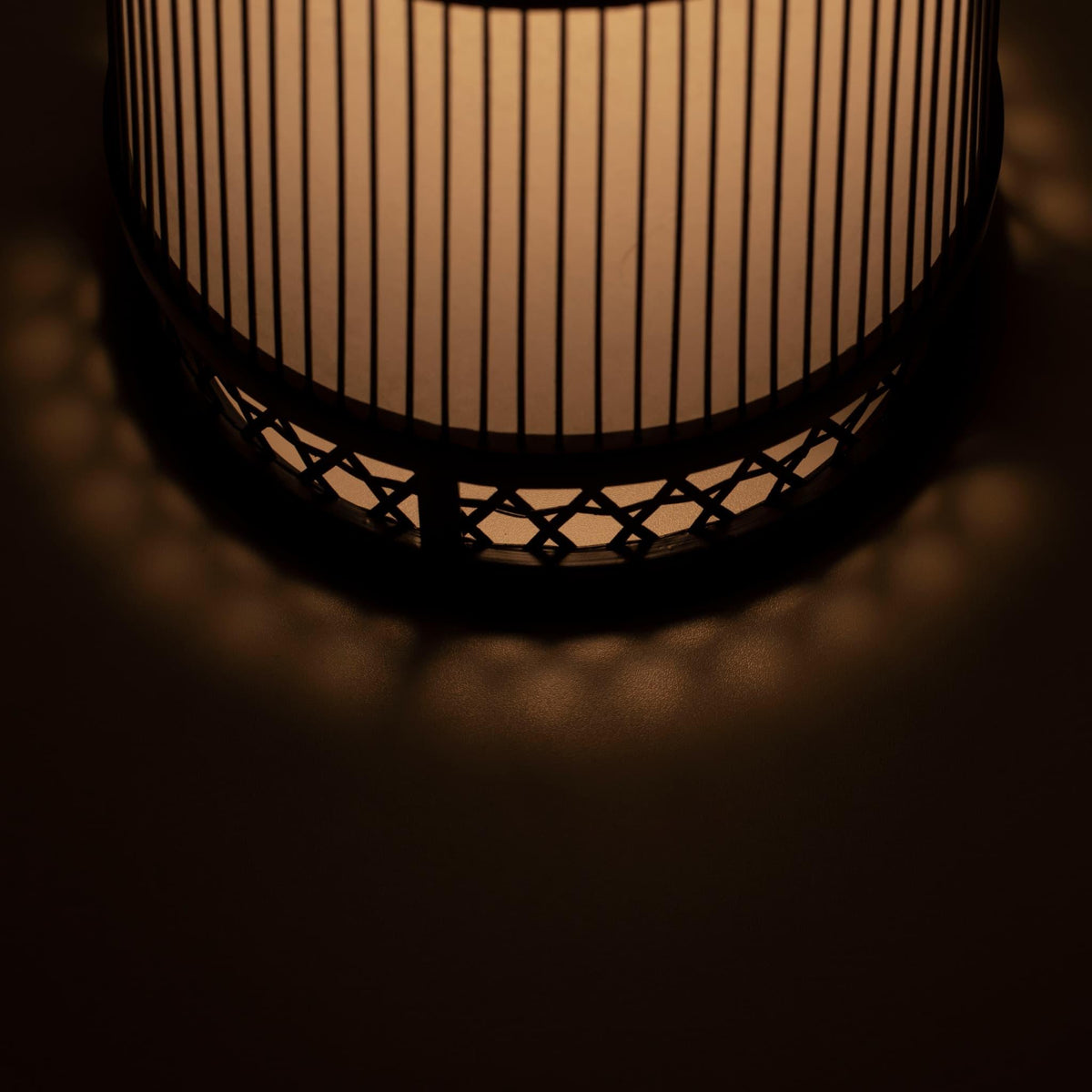 "Een Japanse bamboe vloerlamp verlicht de ruimte en werpt unieke schaduwen."