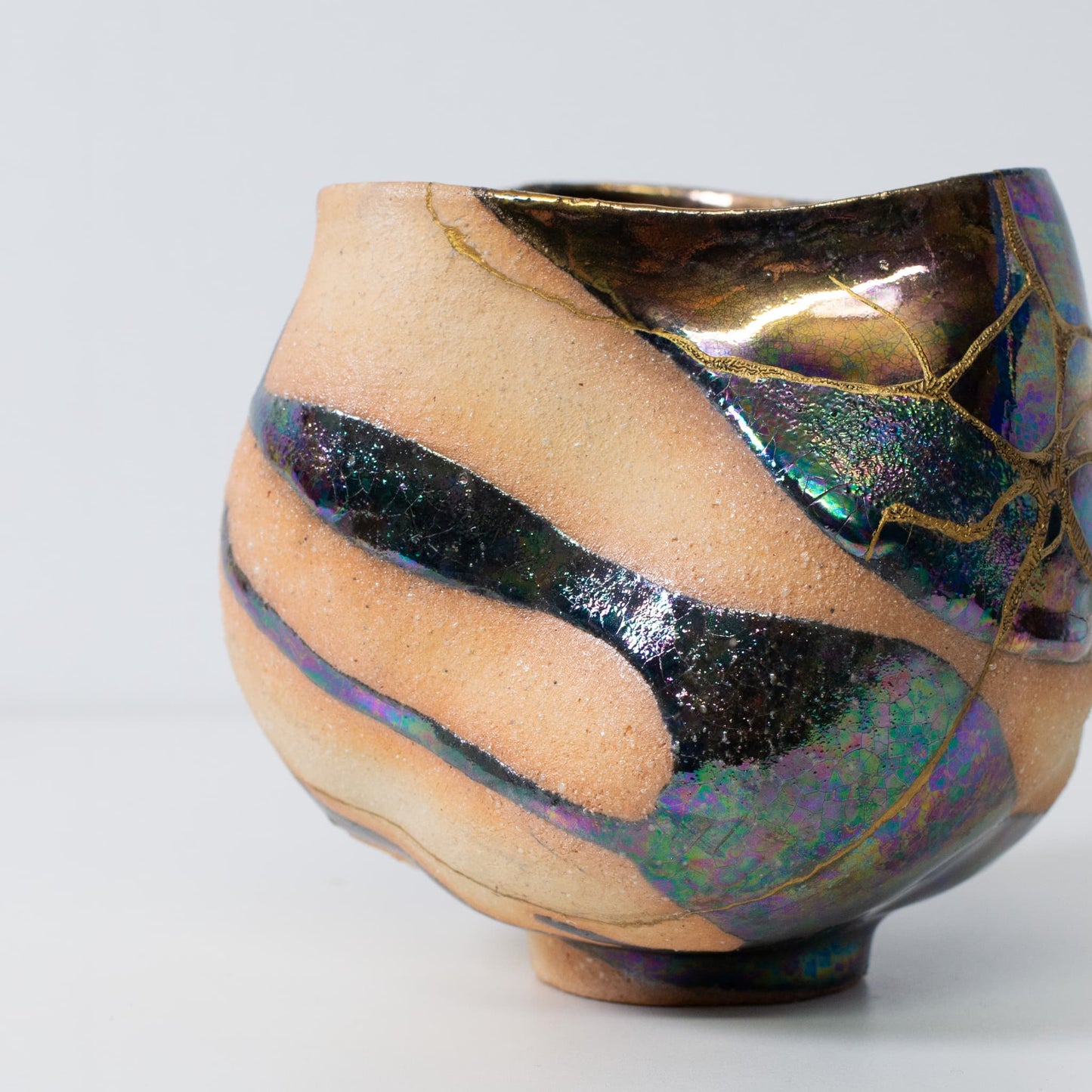 Close-up of kintsugi art matcha bowl highlighting gold repair lines and ceramic texture