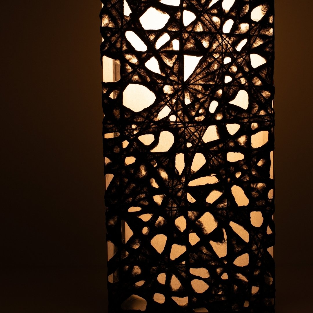 Close-up glowing black Japanese floor lamp ME-LOOK 01, intricate Melook washi paper