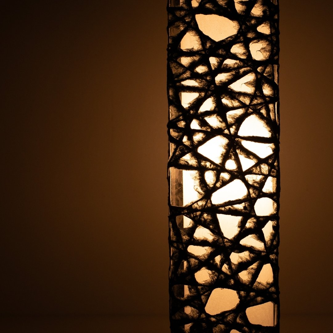 Close-up glowing black Japanese floor lamp ME-LOOK 02, intricate Melook washi paper shade