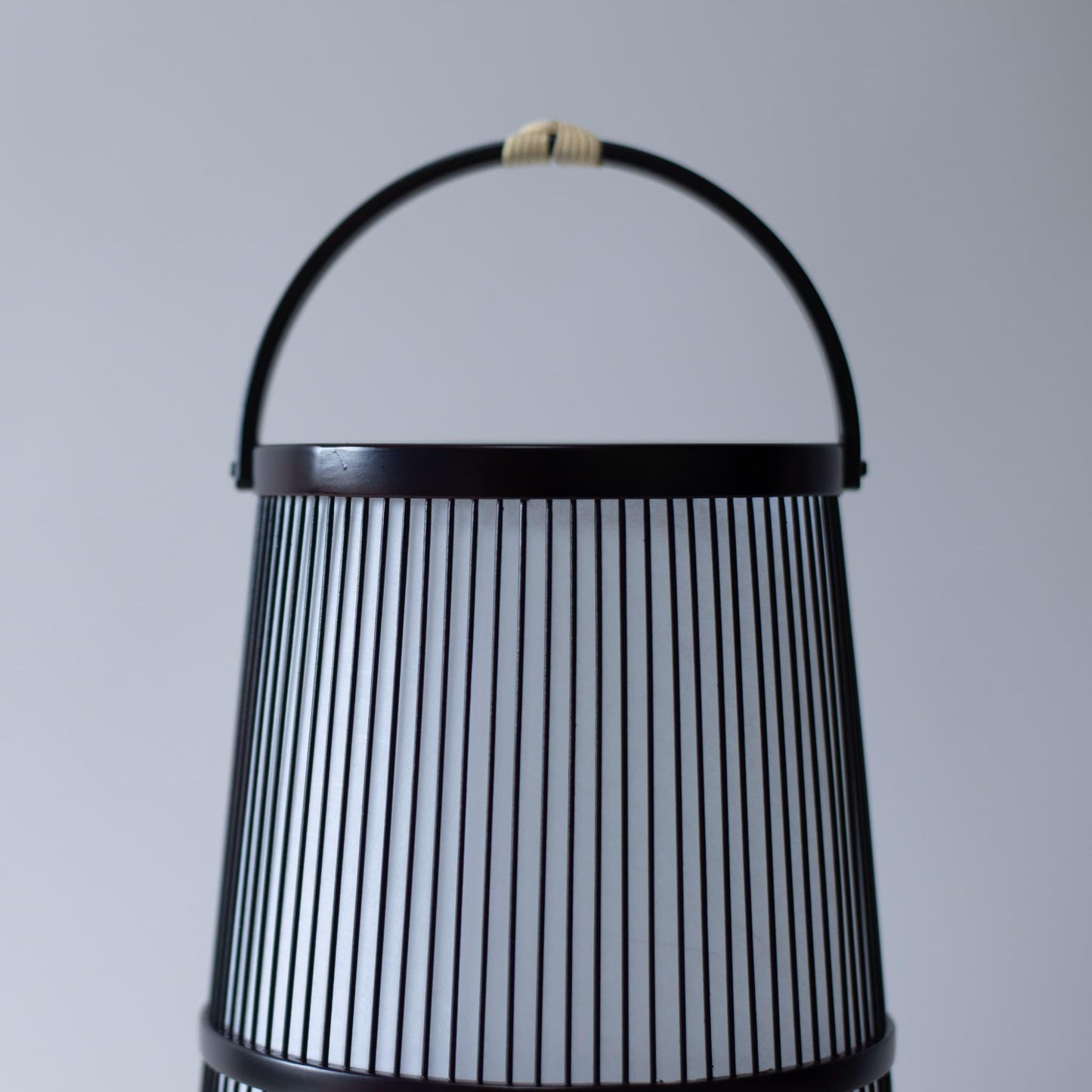 An close-up of the top and handle of the Japanese bamboo lamp "Hagoromo."