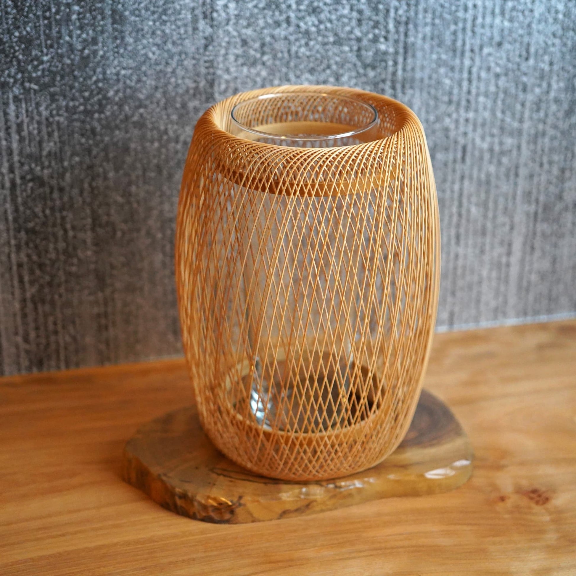 A delicate, cocoon-shaped Japanese ikebana vase made from bamboo, featuring beautifully interwoven bamboo strips.