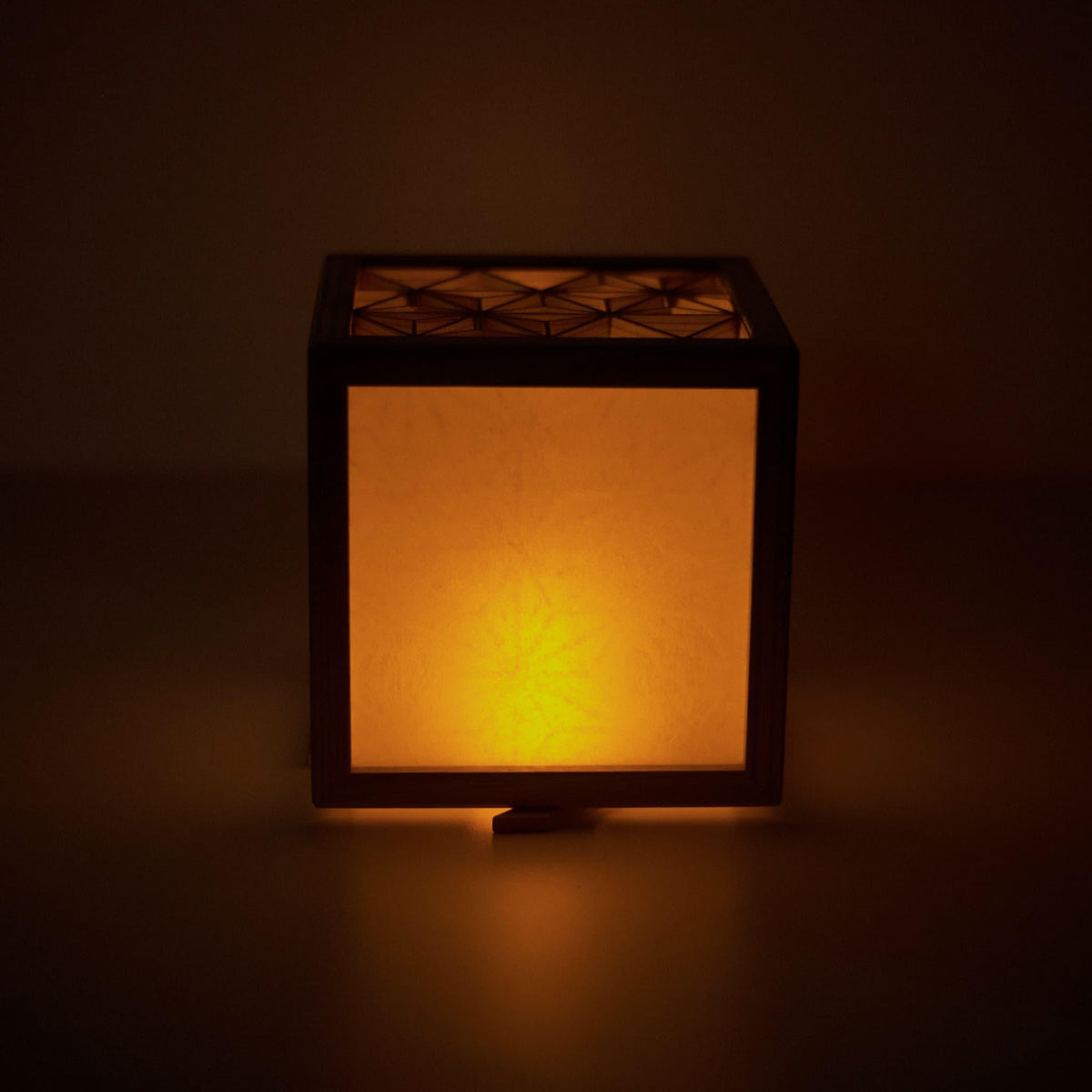 Vorderansicht einer mittelgroßen Kumiko-Lampenabdeckung, die das elegante Design und den warmen Lichtschein zeigt.