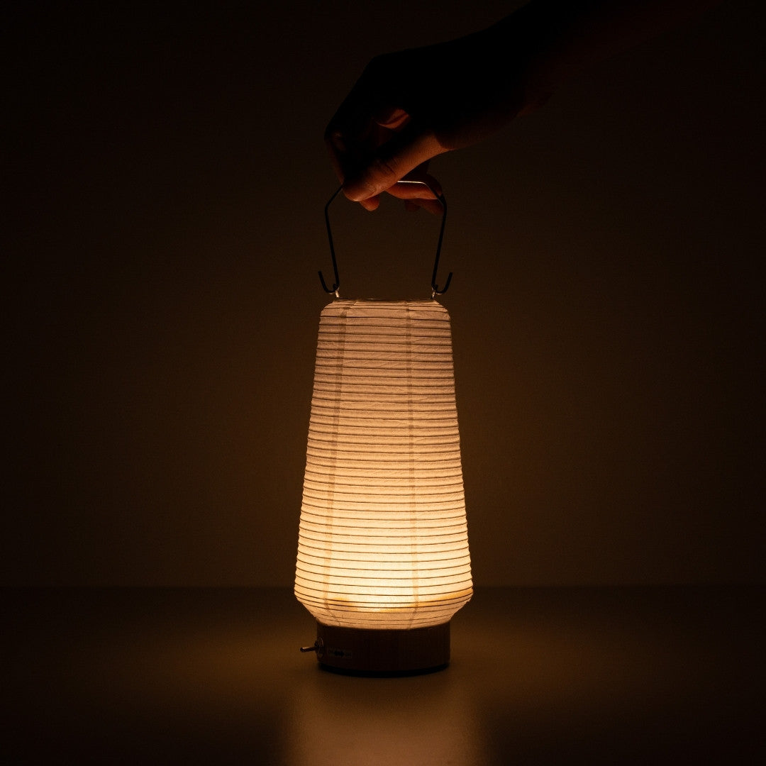 Hand holding slim Japanese paper table lamp RIN 04, portable vertical Japanese paper lamp