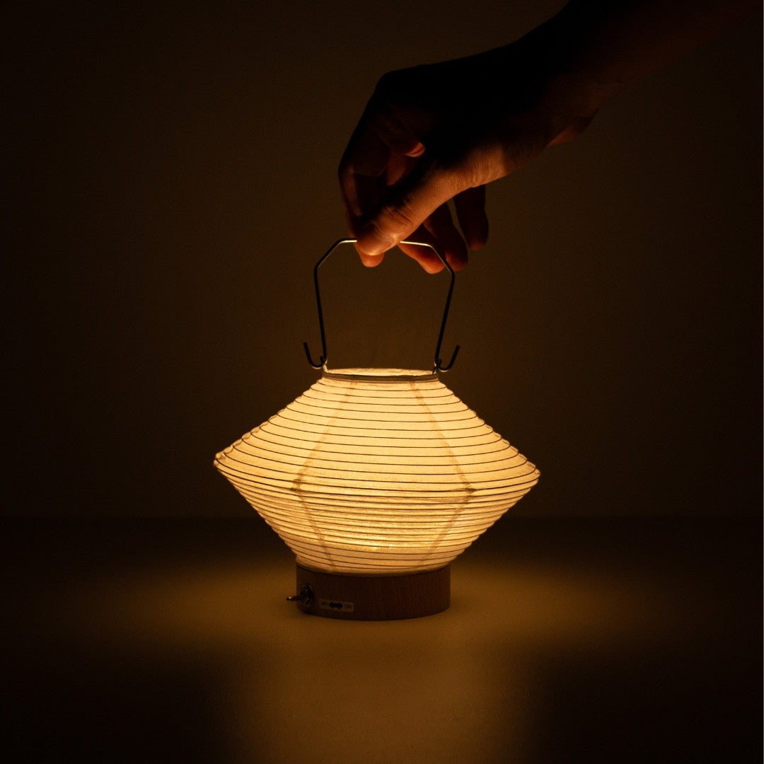 Hand holding diamond-shaped Japanese paper table lamp RIN 05, portable Japanese table lamp for living room & bedroom