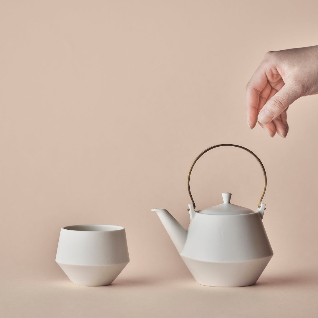 Elegant Japanese teapot with brass handle and yunomi tea cup for serving green tea