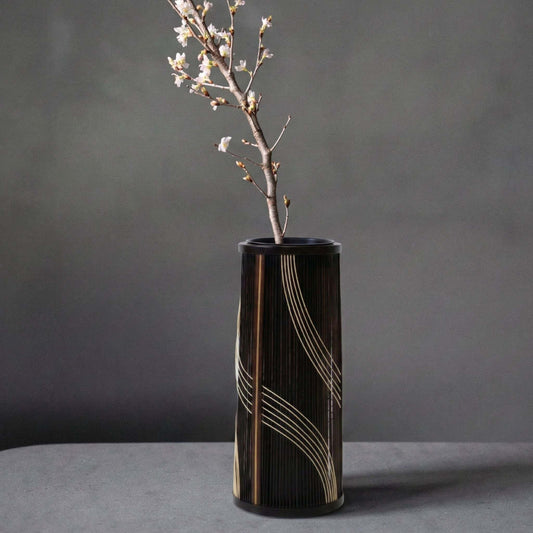 Japanese bamboo vase titled "Flowing Water" displayed on a gray hotel table.