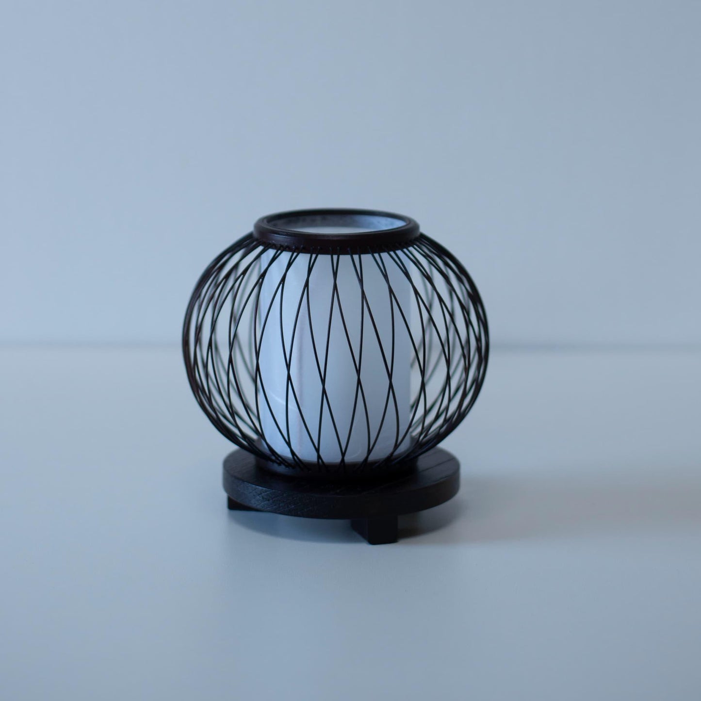 A Japanese bamboo table lamp placed on a white table.