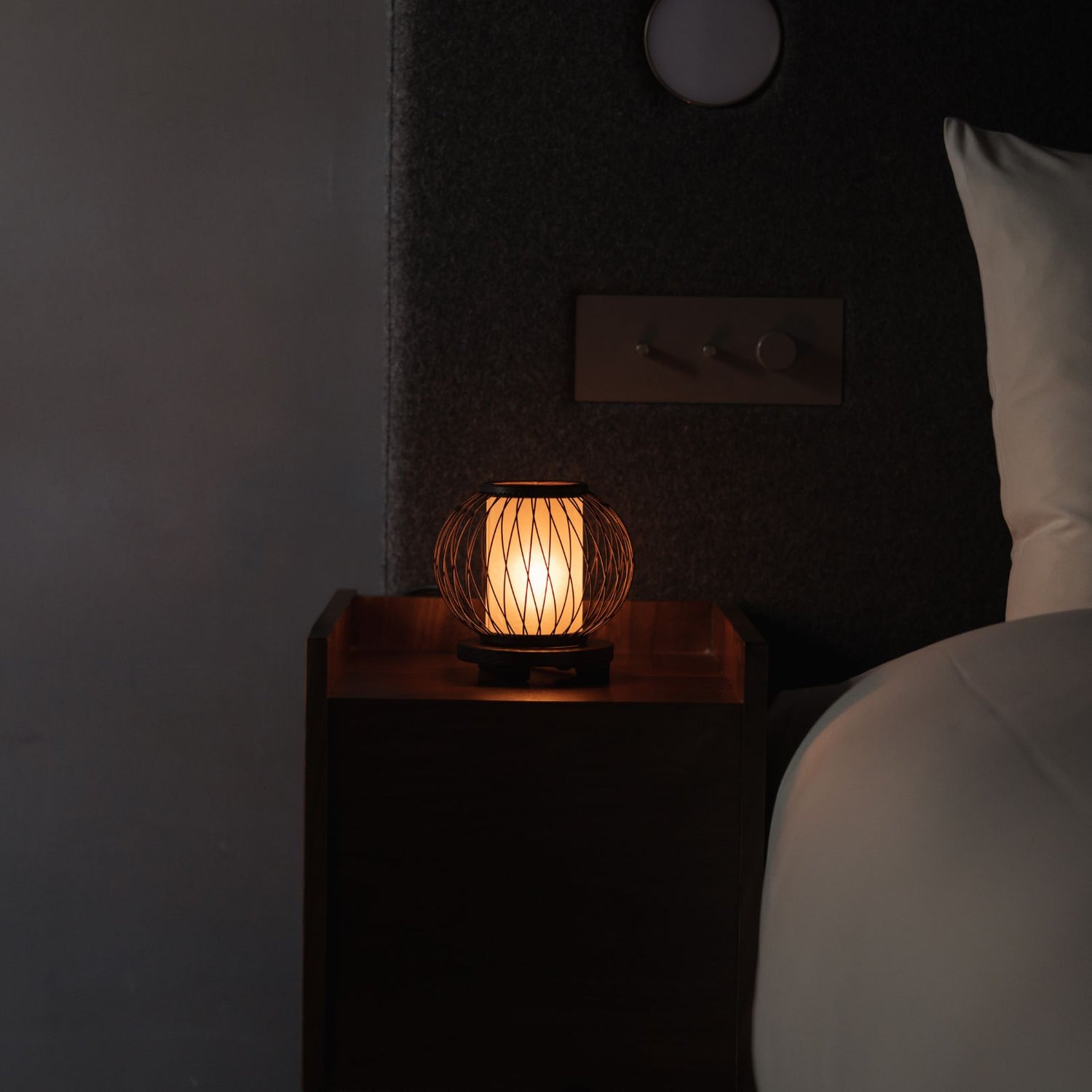 Japanese Bamboo Table Lamp "Moon Rabbit" emits warm glow on a bedside table in Japandi bedroom