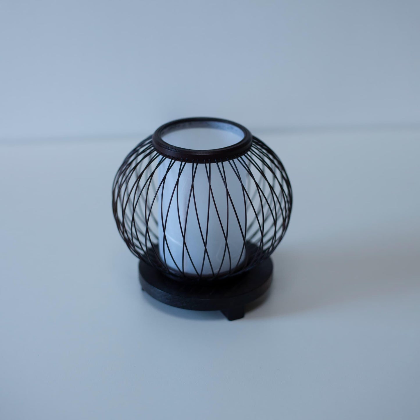 A Japanese bamboo table lamp placed on a white table.