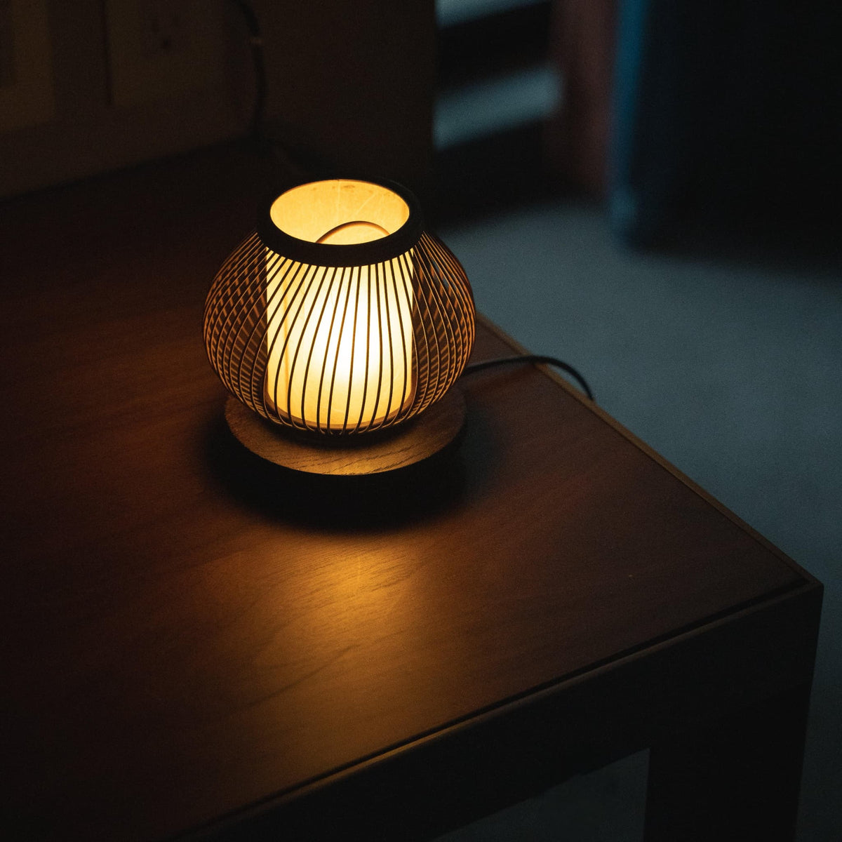 Lampe de chevet japonaise en bambou sur une table.