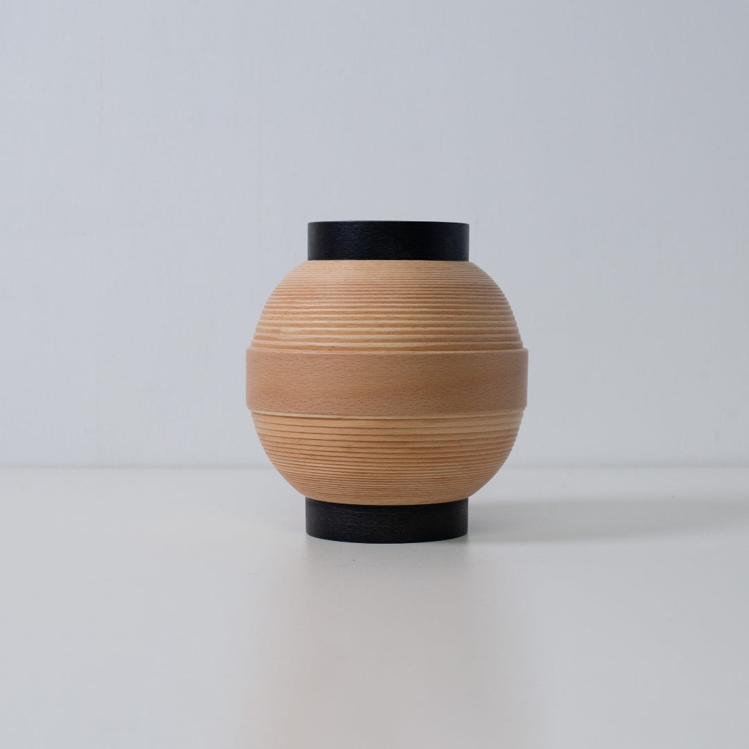 Handcrafted Japanese table lamp with round beechwood form, ideal for modern living spaces.