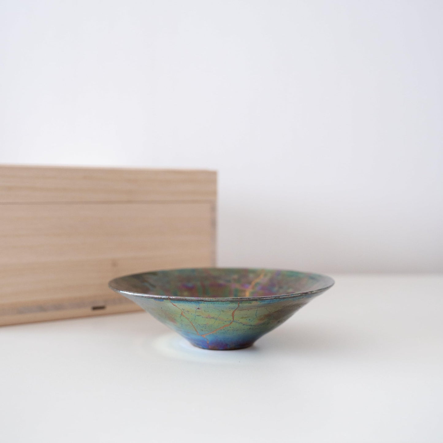 Gift set of a deep green sake cup repaired with Kintsugi, a traditional Japanese technique, and a paulownia wood box.