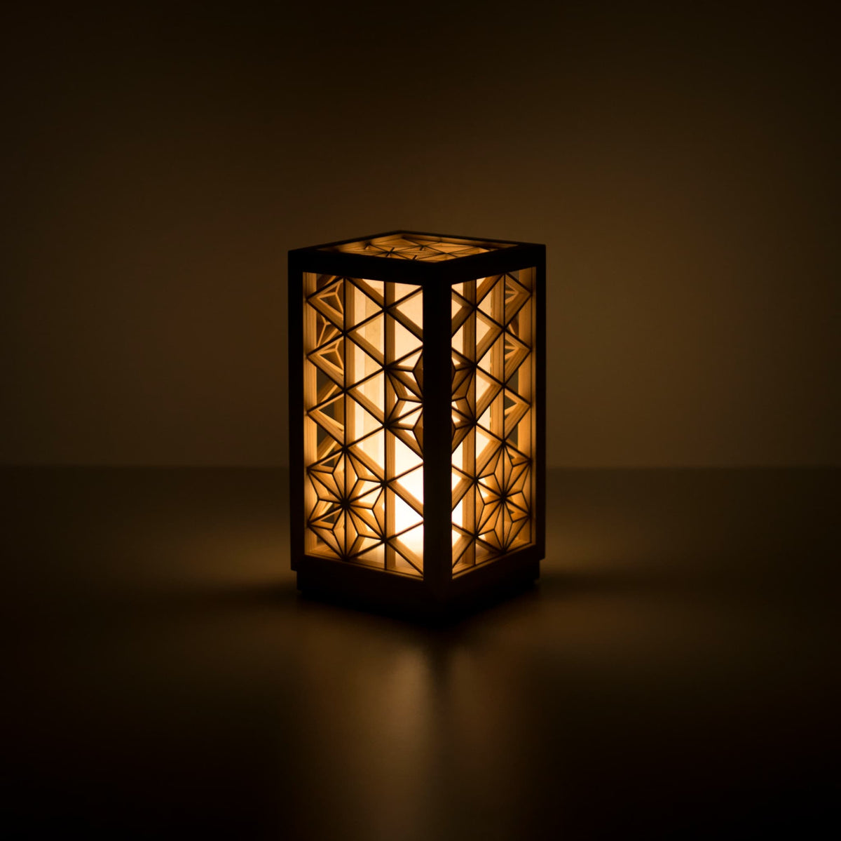 Une lampe de table utilisant le kumiko, une technique japonaise traditionnelle d'assemblage de petites pièces de bois pour créer des motifs géométriques.