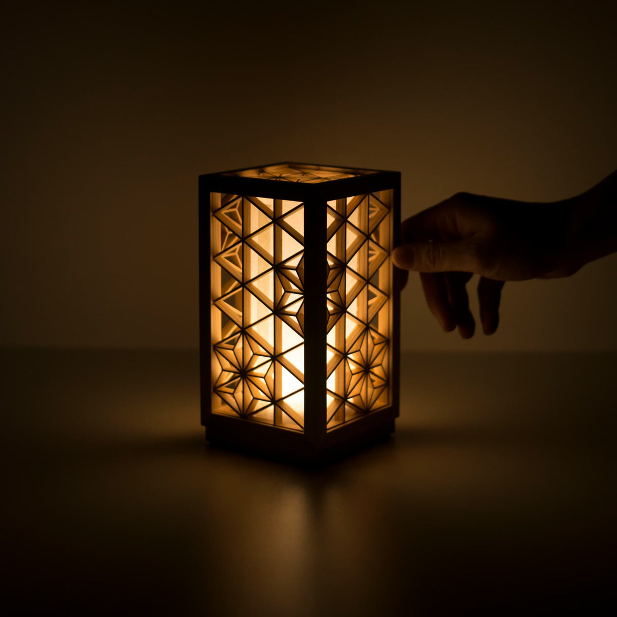 Une lampe de table utilisant le kumiko, une technique japonaise traditionnelle d'assemblage de petites pièces de bois pour créer des motifs géométriques.