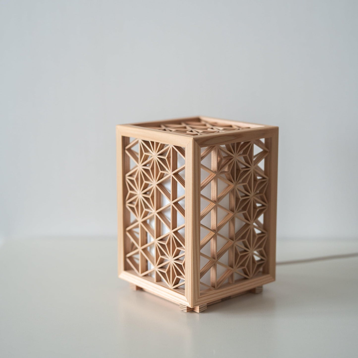 Japanese Kumiko Table Lamp "Asanoha" on a white table