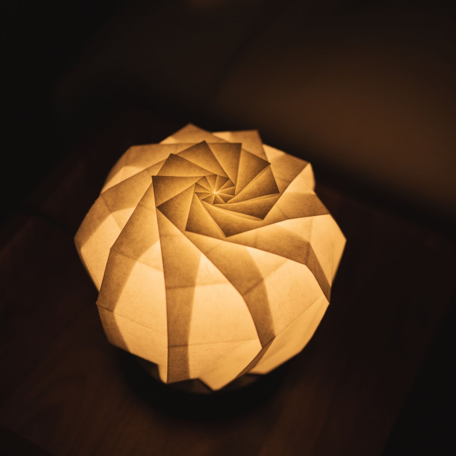 A Japanese paper table lamp on a bedside table.
