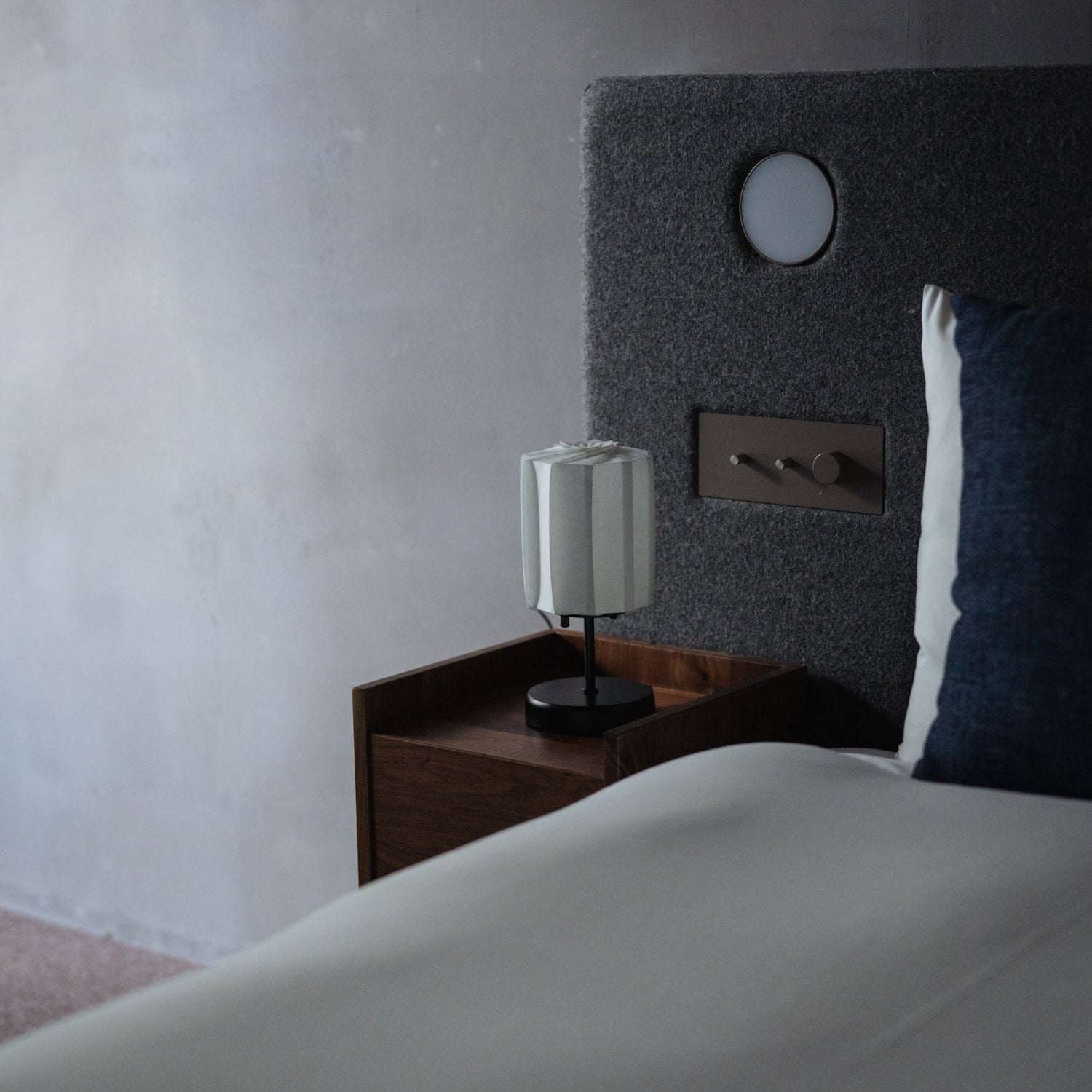 A Japanese Origami Paper Lamp "Flower of Light" on a bedside table.