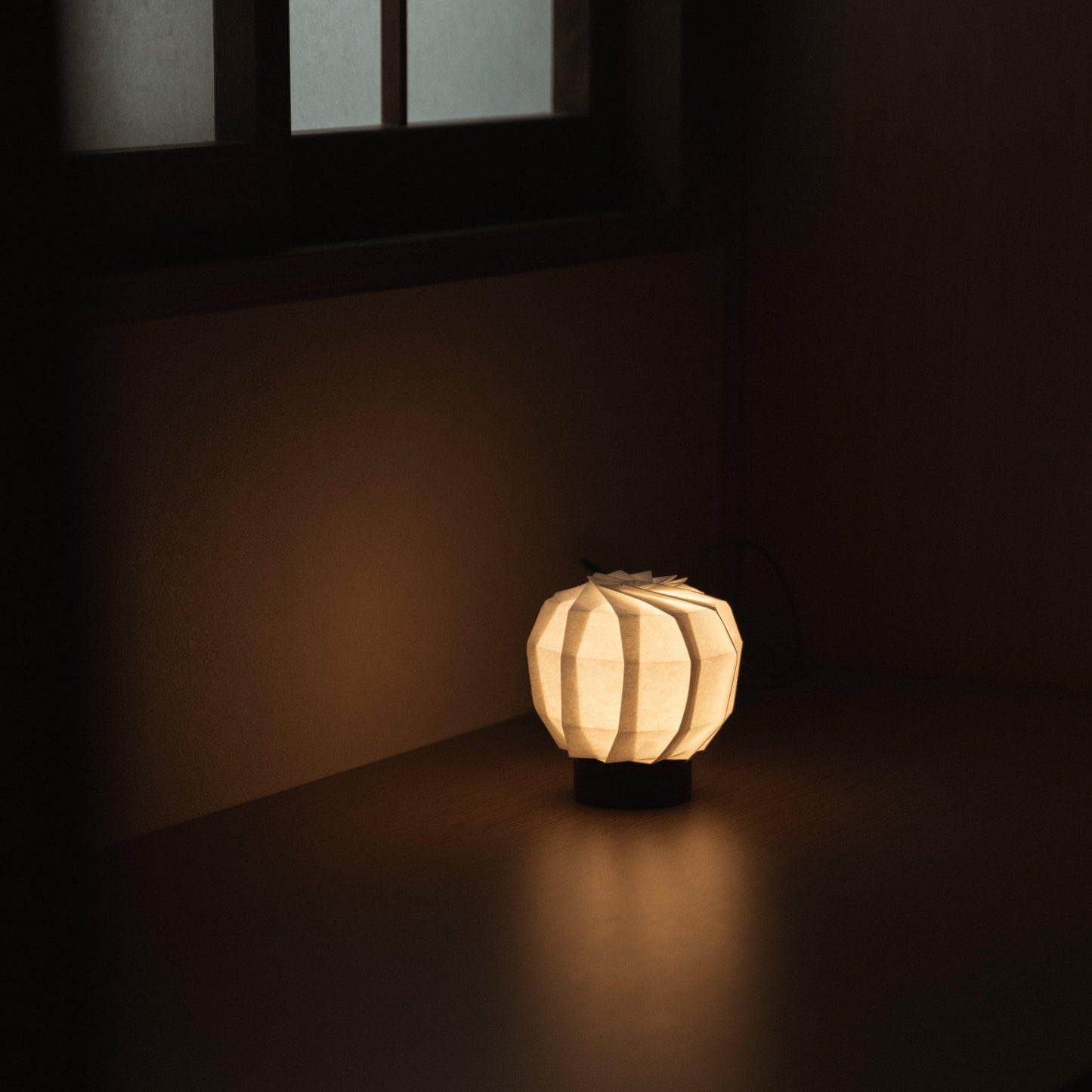 Unique Japanese paper table lamp, crafted with origami techniques, adding a touch of modern elegance and soft illumination to any space.