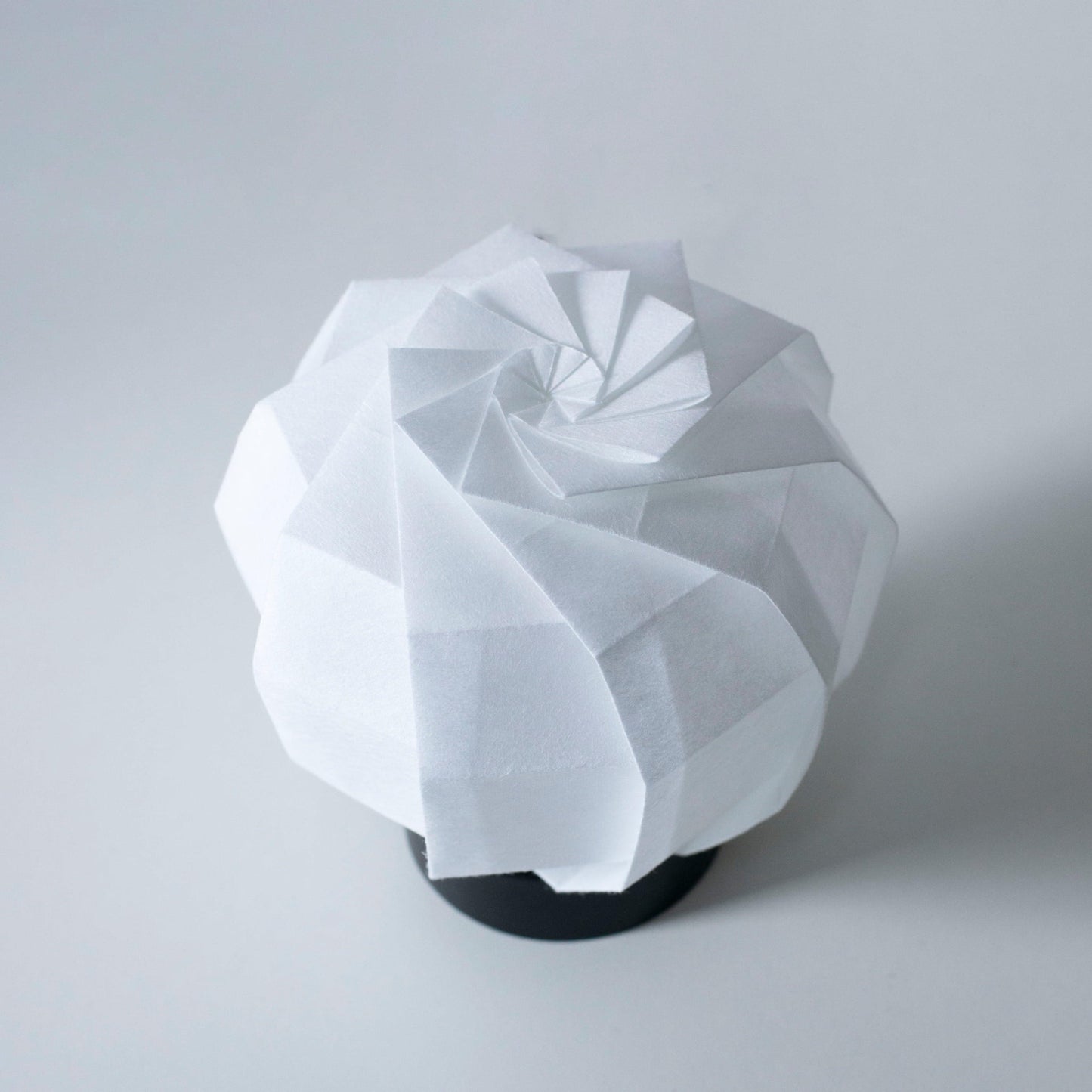 Frameless Japanese Paper table lamp crafted with traditional Kyo-hyogu and origami techniques, featuring a unique origami pattern.