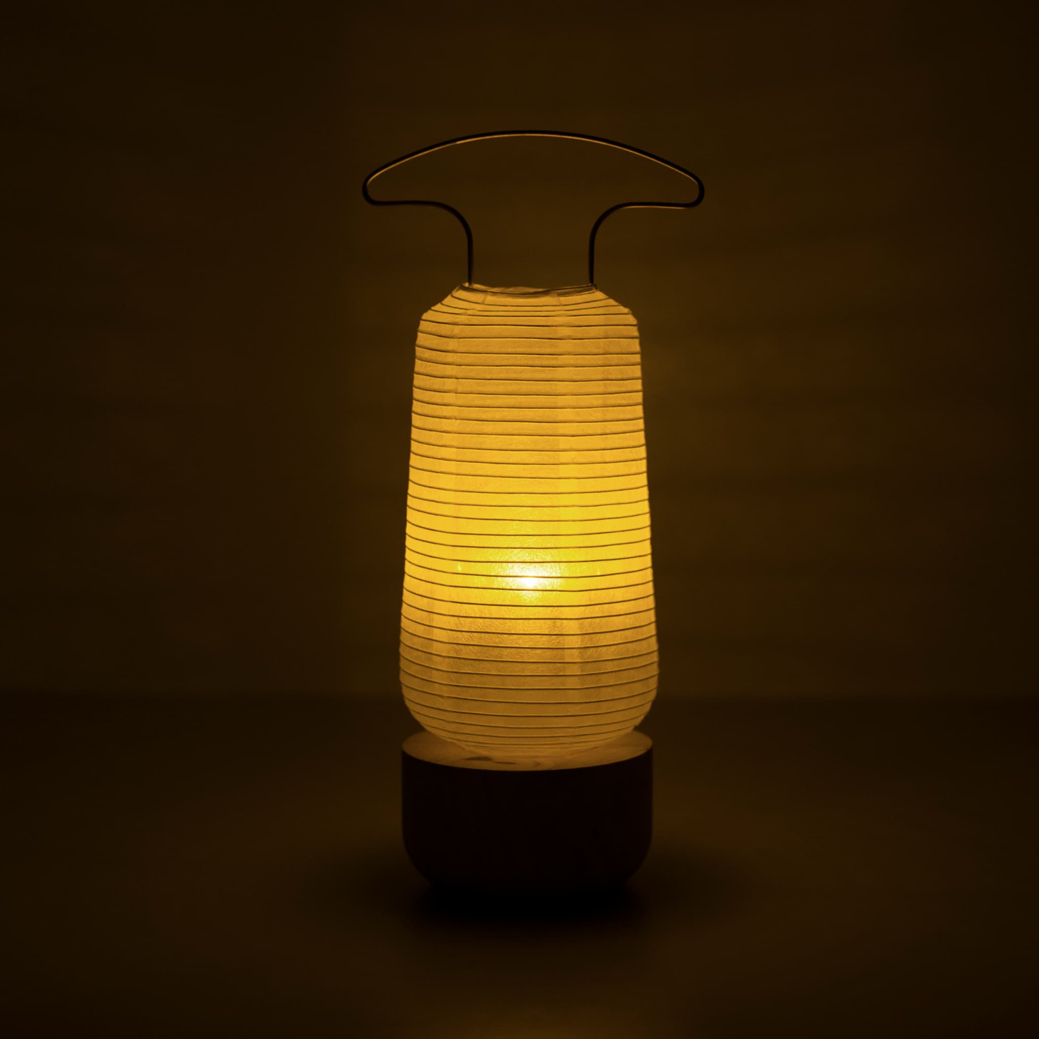 Traditional Japanese paper lantern lamp glowing warmly in a dark room