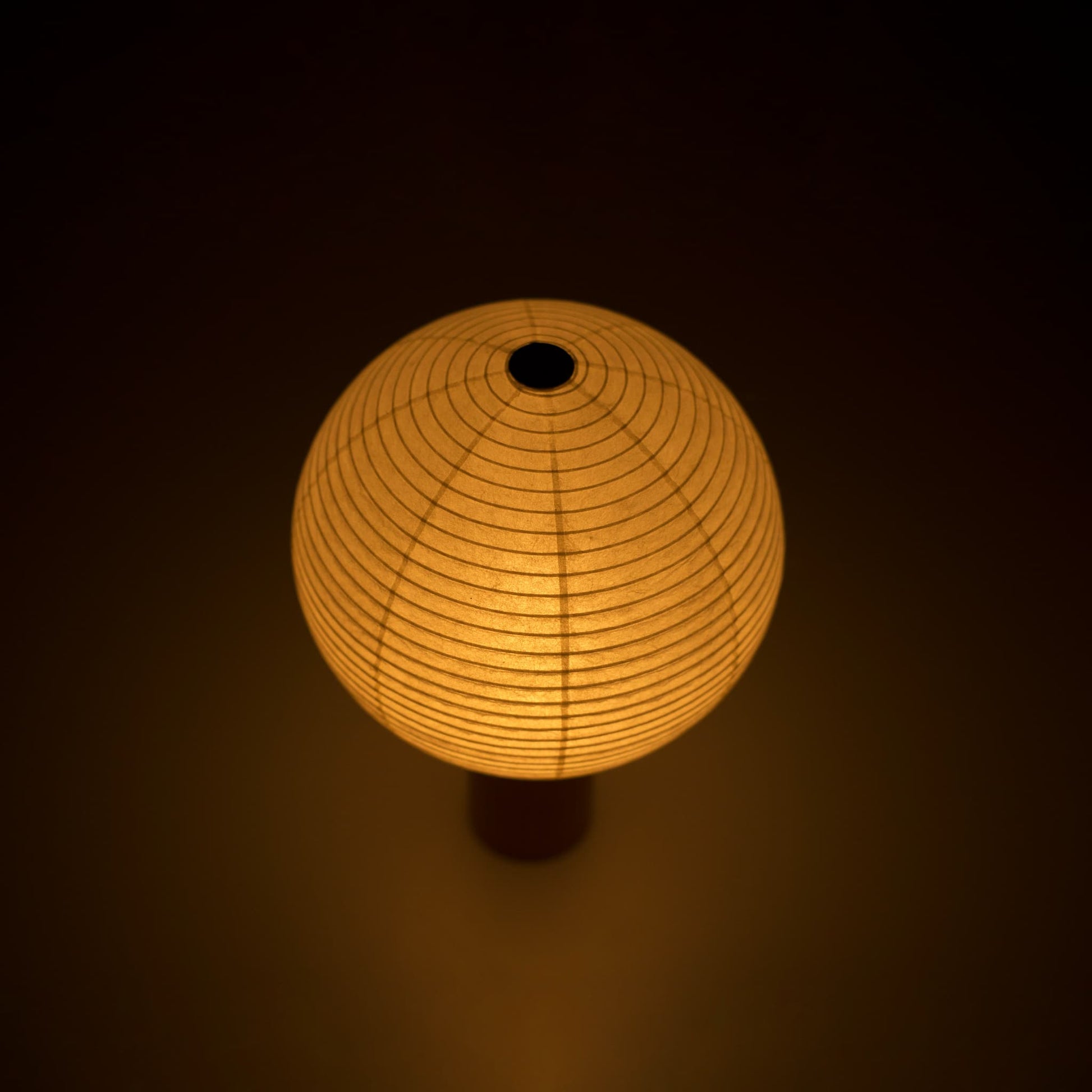 Japanese paper lantern "TORCHIN CIRCLE" emitting a warm glow, handcrafted in Yame, Fukuoka, Japan, known for its traditional Yame lanterns.