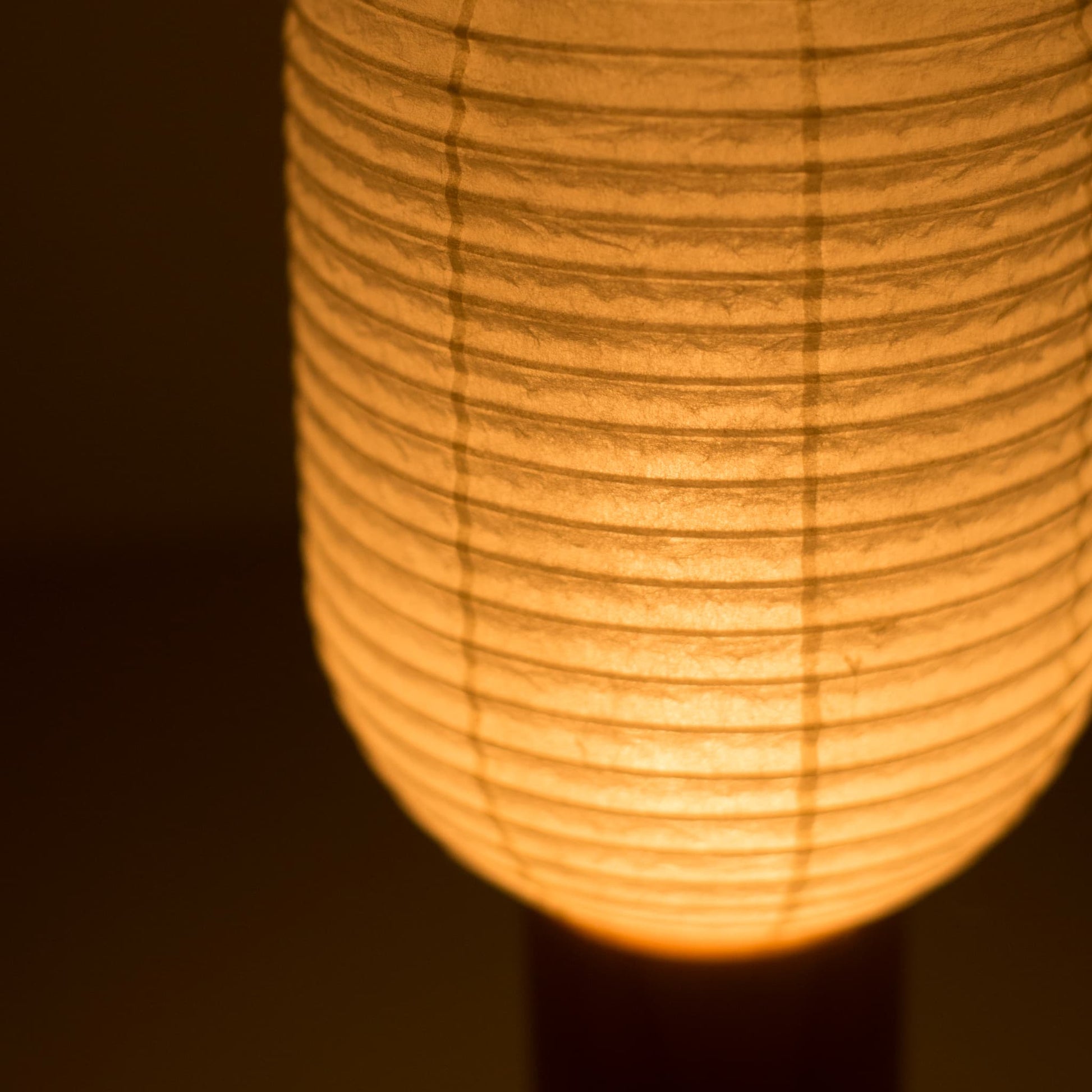 Close-up of the "TORCHIN VERTICAL"  Japanese paper lantern, showcasing the intricate details of the washi paper shade and the warm light it emits.