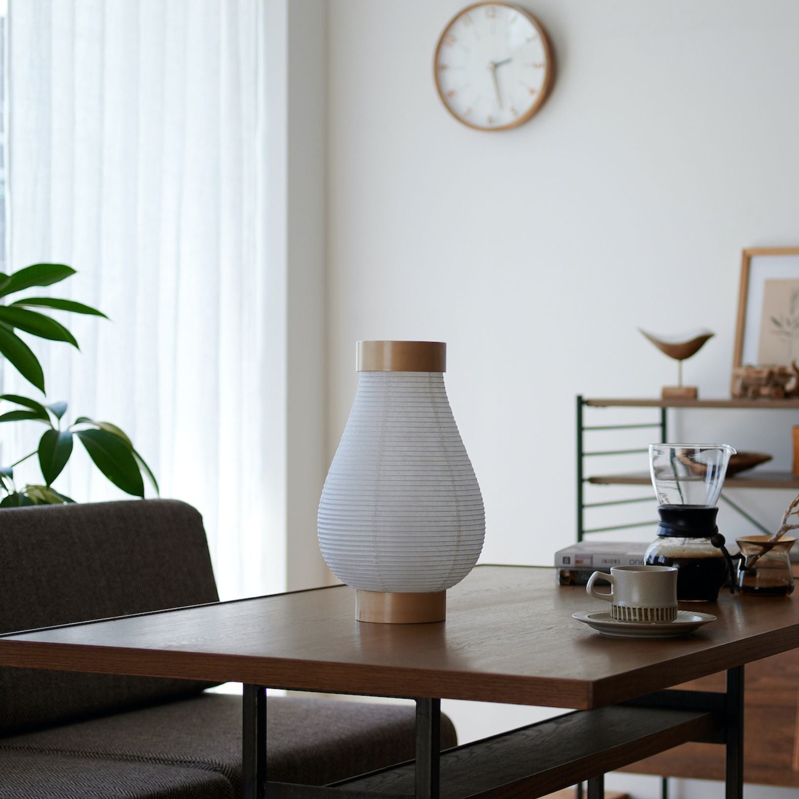 A traditional Japanese paper lantern lamp on a table in a Japandi style living room