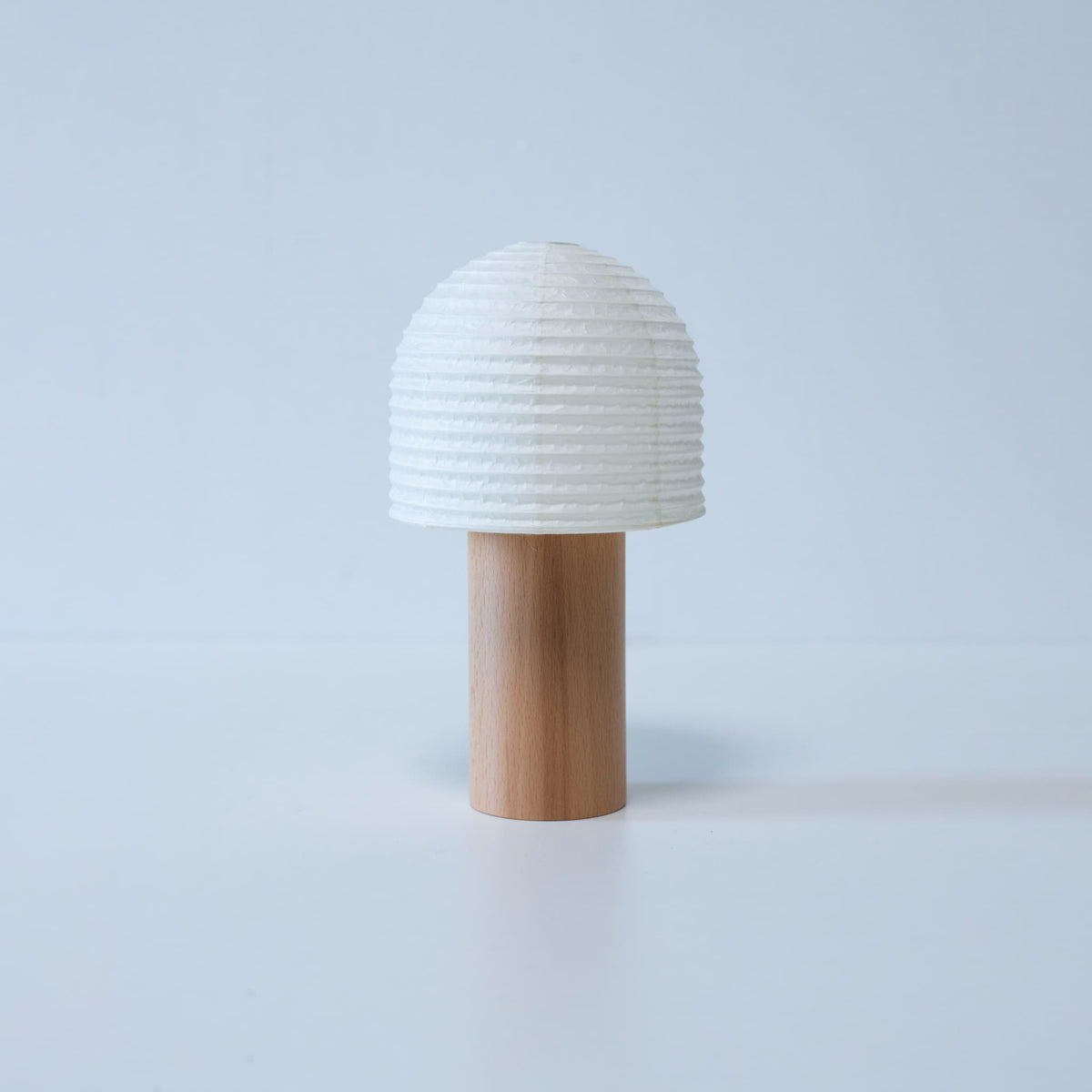 Japanese Paper Lantern with Bell-Shaped Top Against White Background A portable Yame lantern with a bell-shaped top and wooden handle against a white background