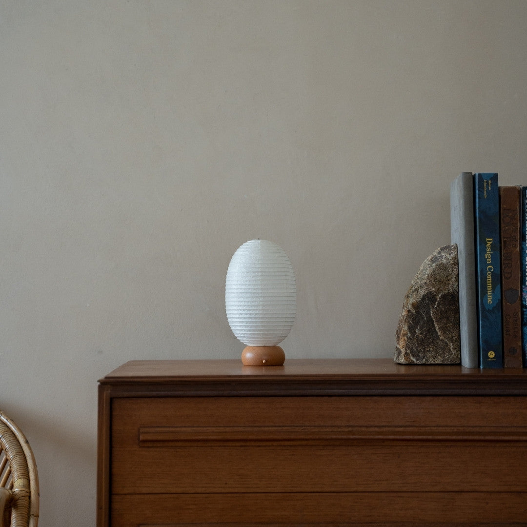 Japanese Paper Table Lamp "Dinosaur" on wooden shelf in Japandi style living room – Paper table lamp for Japandi interior