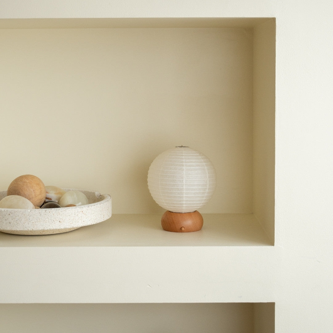 Japanese Paper Table Lamp "Mini Circle" on a white shelf in Japandi style living room – portable paper lamps for side tables