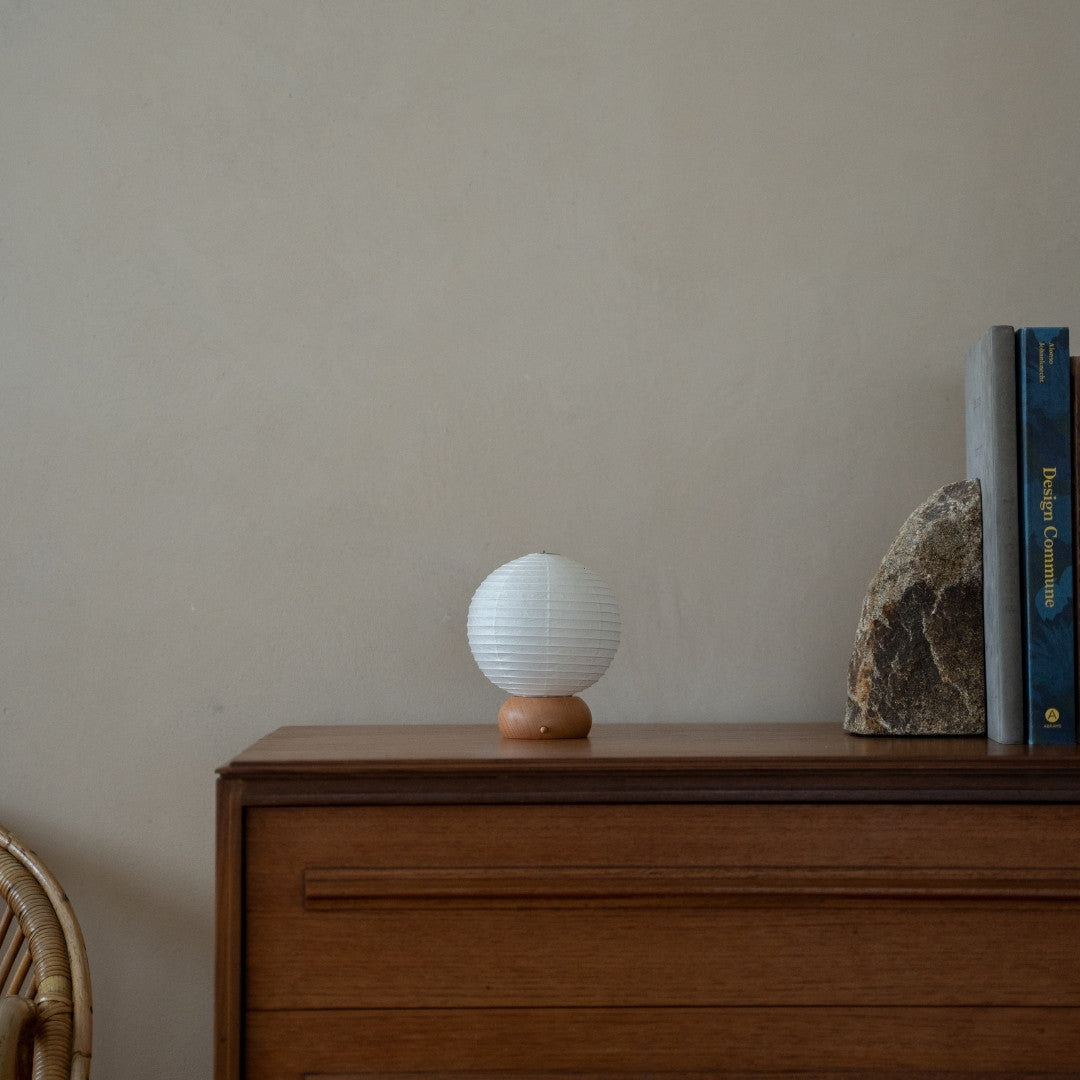 Japanese Paper Table Lamp "Mini Circle" on wooden shelf in Japandi style living room – Wabi-Sabi paper lamp for side table