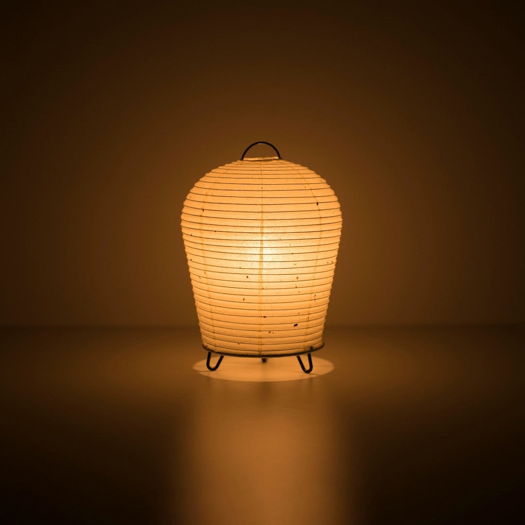 Japanese Paper Table Lamp "PAPERSON 01" emitting warm glow in a dark room – Unique Paper Bedside Lamp for Japandi Bedroom