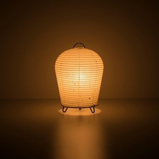 Japanese Paper Table Lamp "PAPERSON 01" emitting warm glow in a dark room – Unique Paper Bedside Lamp for Japandi Bedroom