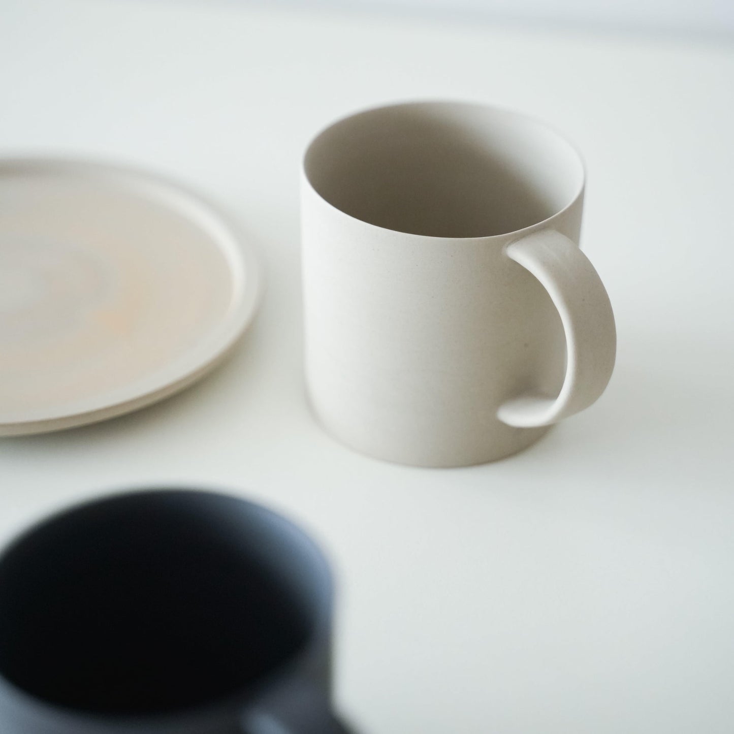 A set of simple white coffee mug and white plate