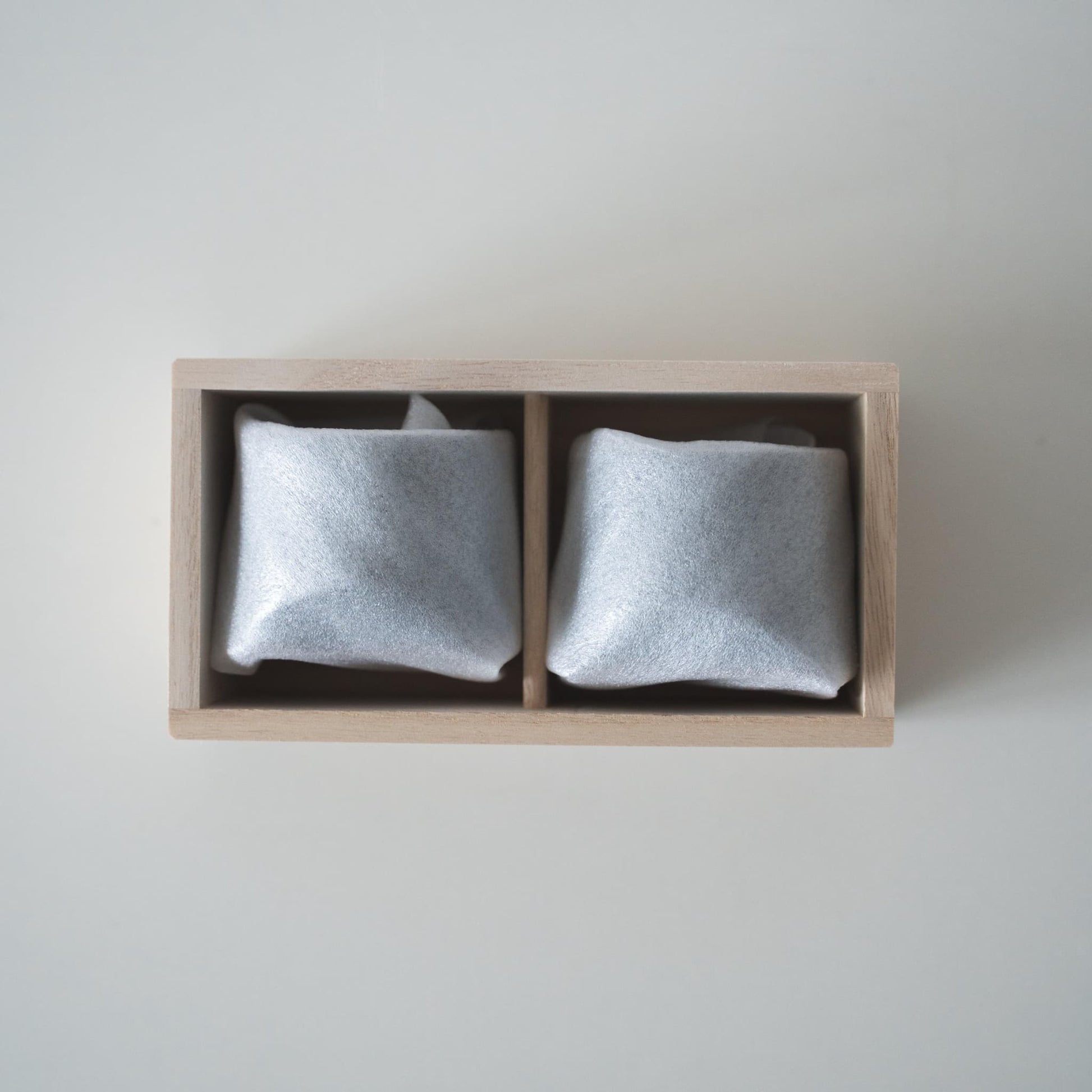 Gift set of two iron-colored sake cups, crafted using traditional Japanese roof tile techniques, presented in a paulownia wood box.