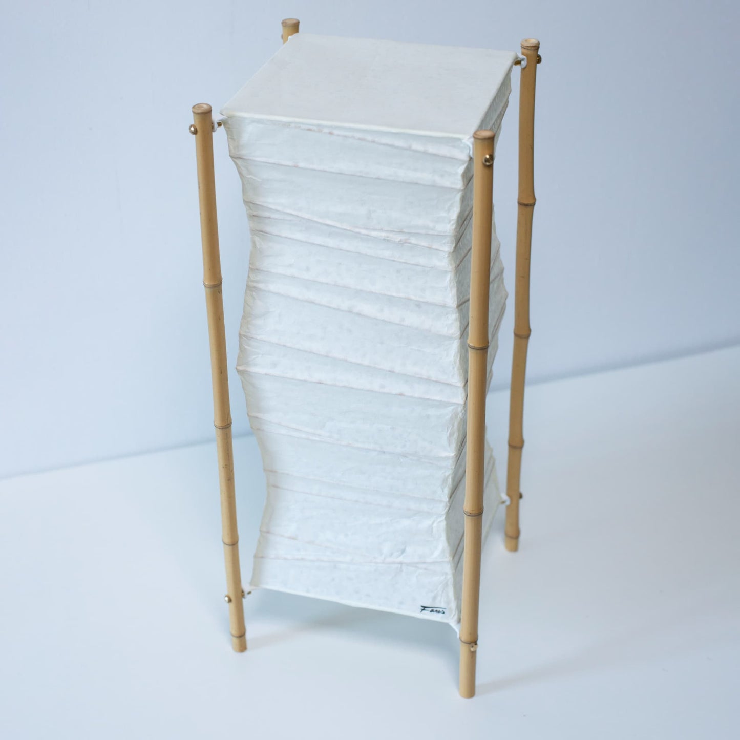 A Japanese paper floor lamp on white background.