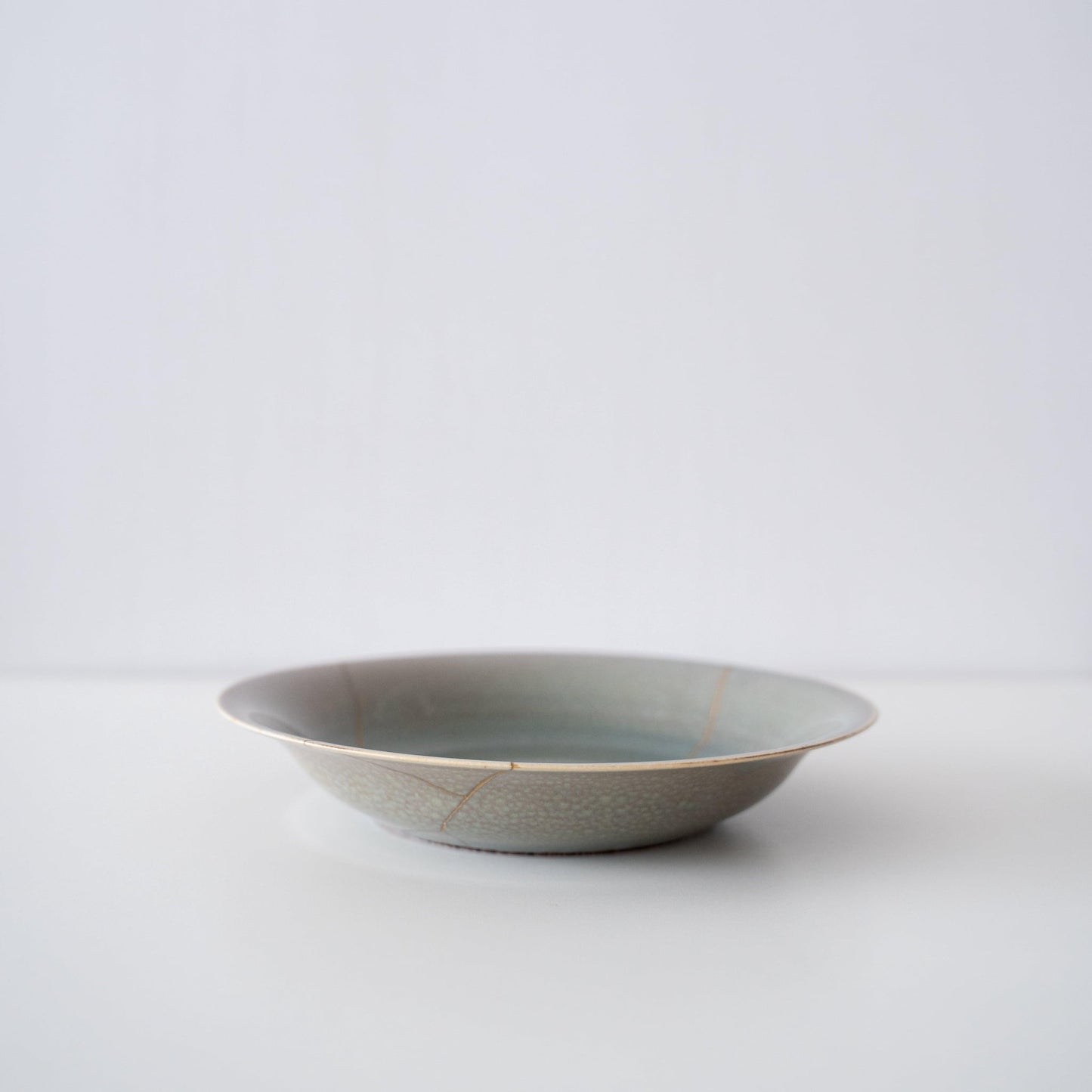 Side view of Kintsugi Bowl "Four Color Yohenyu" a white backgroundn
