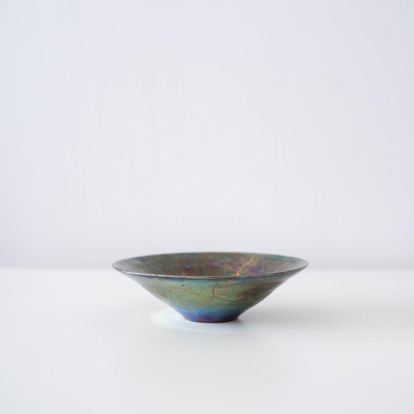 Side view of Kintsugi Bowl "Green Nebula" in a white background