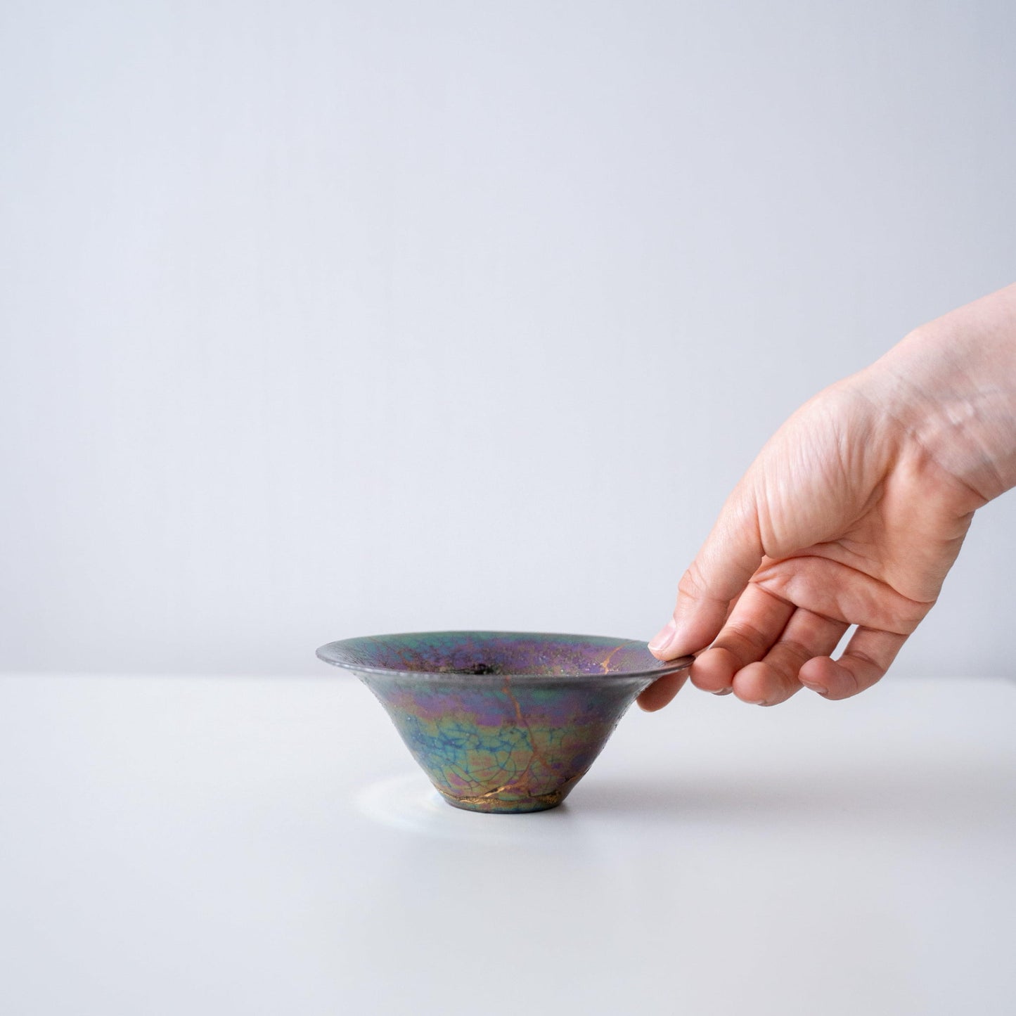 Hand holding Kintsugi Bowl "Rainbow Luster", showing its size and how it fits in the hand