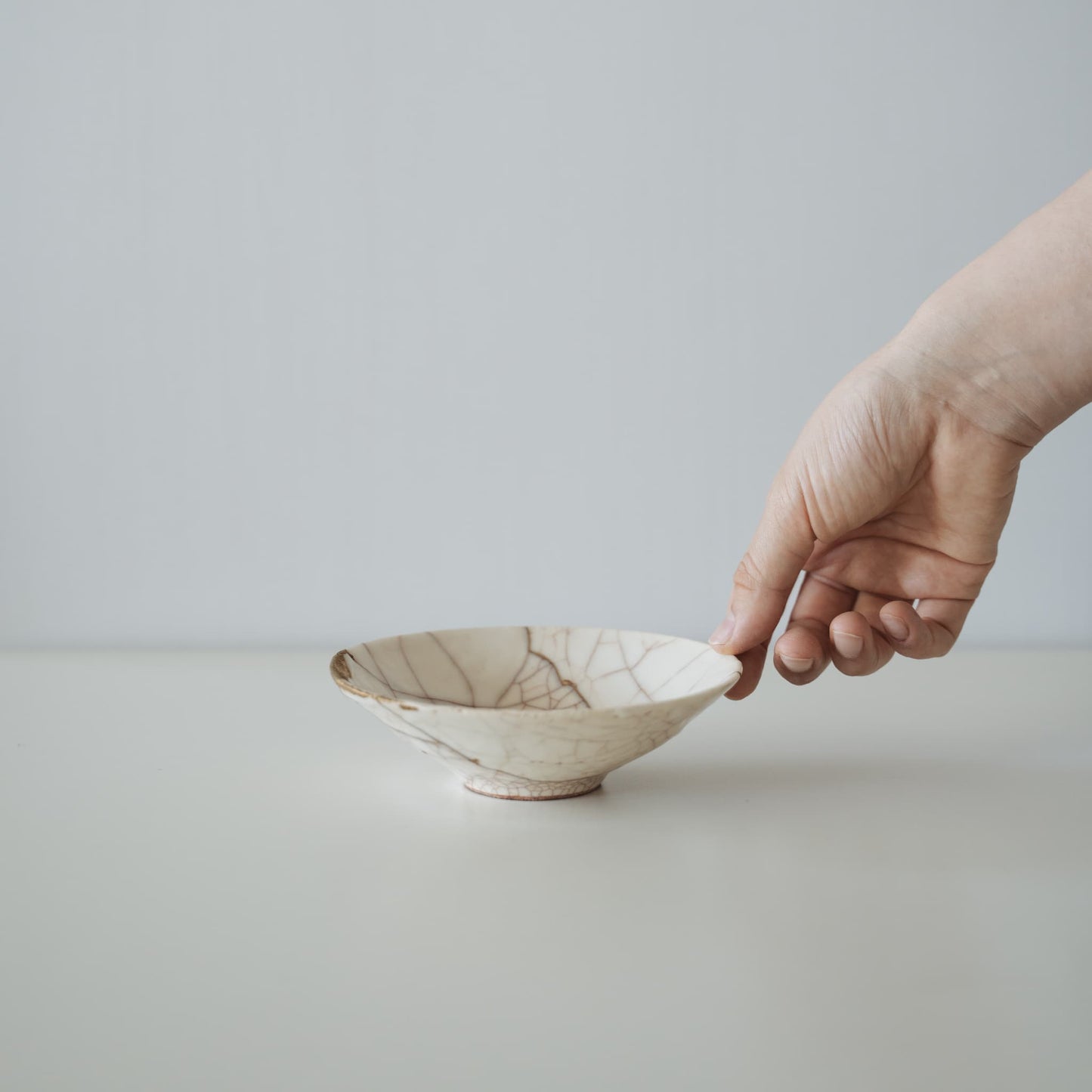 White Kintsugi Bowl with a hand in White Background