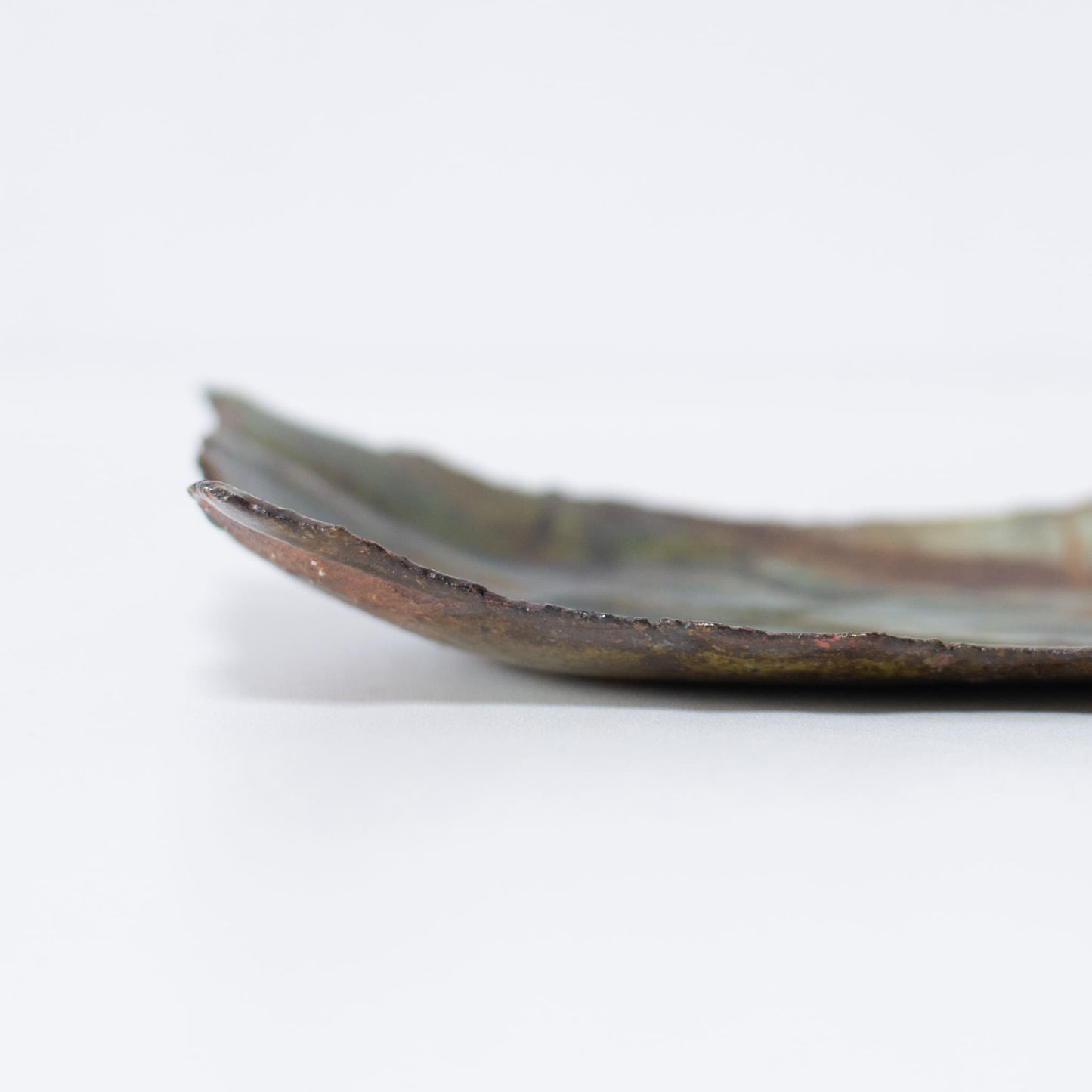 Close-up of the side profile of Kintsugi Plate "Oribe" Deep Green 01, highlighting the texture.
