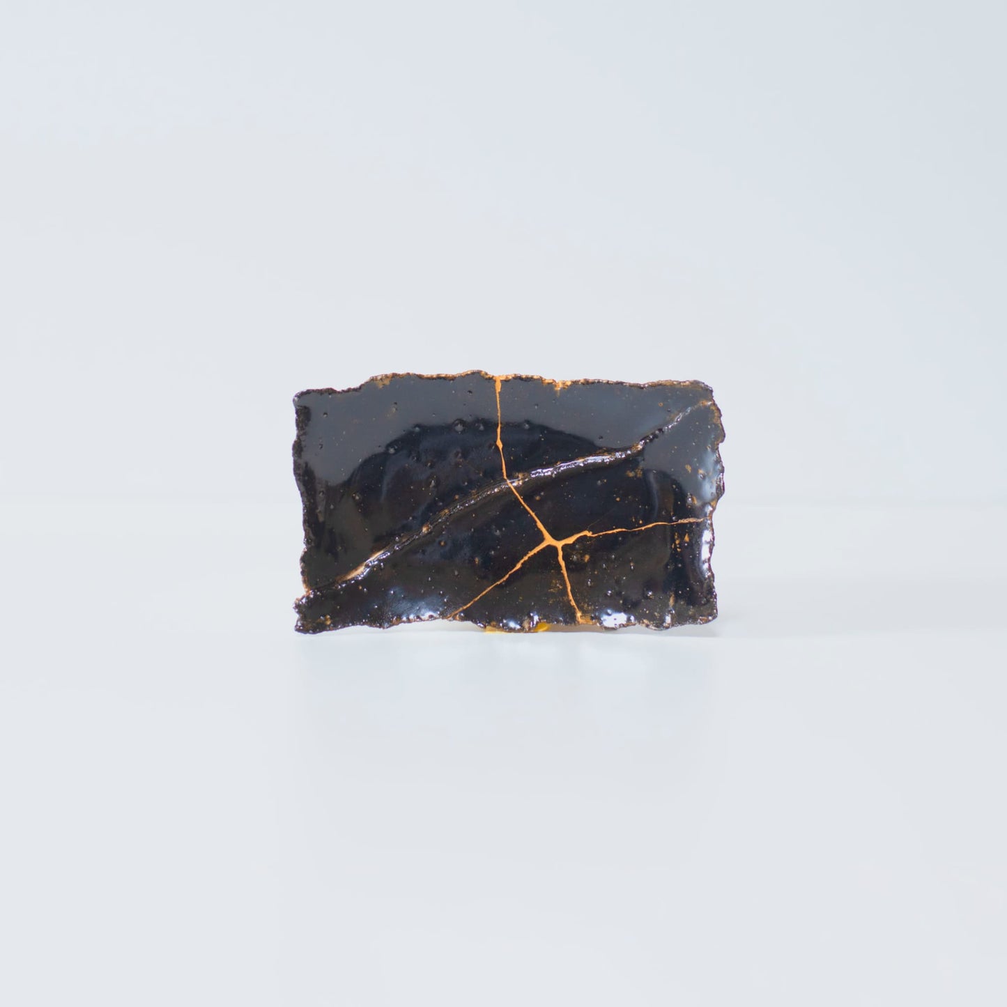 Side view of Kintsugi Plate "Tenmoku" Black 01 in a white background