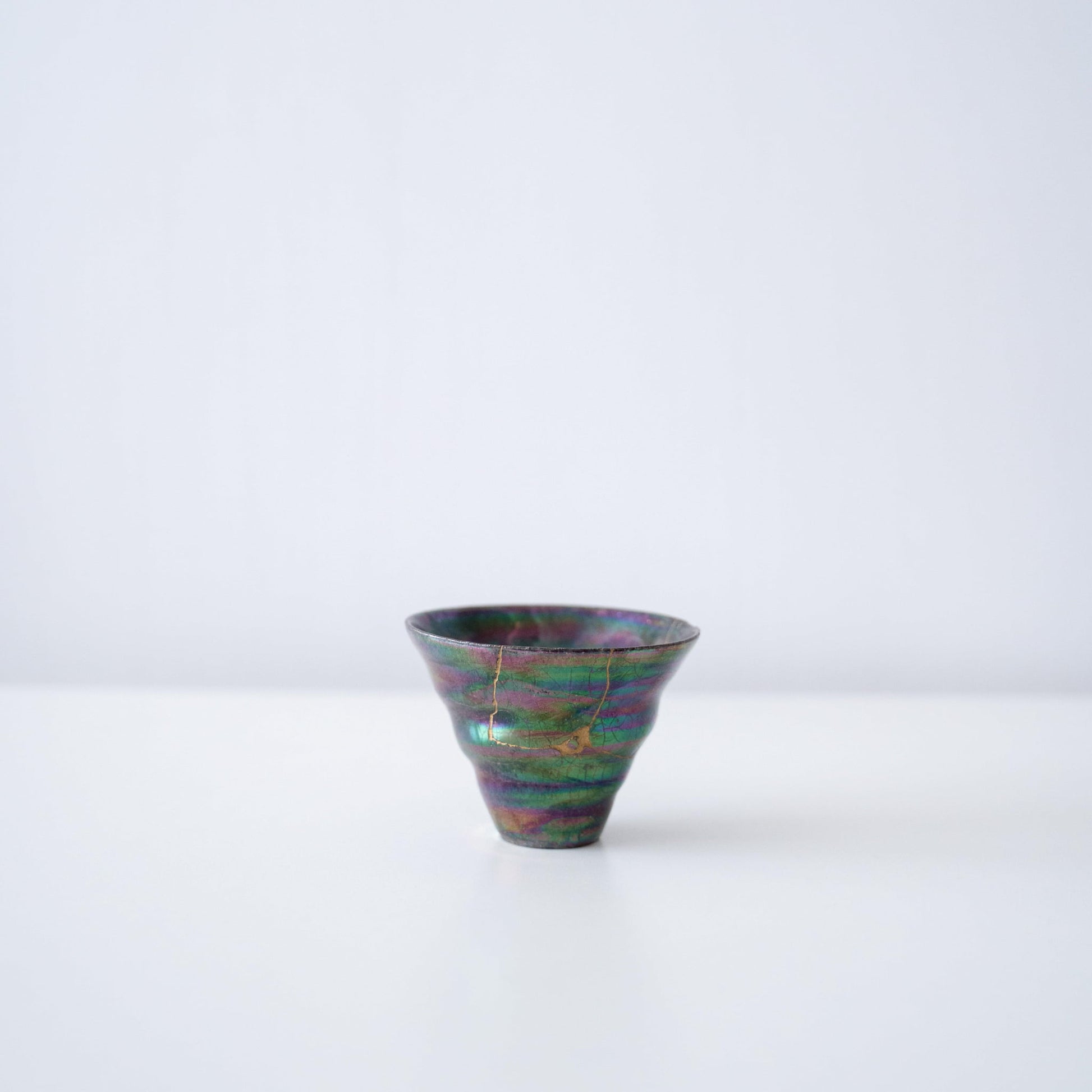 Side view of Kintsugi Sake Cup "Colored Clay Luster" in a white background