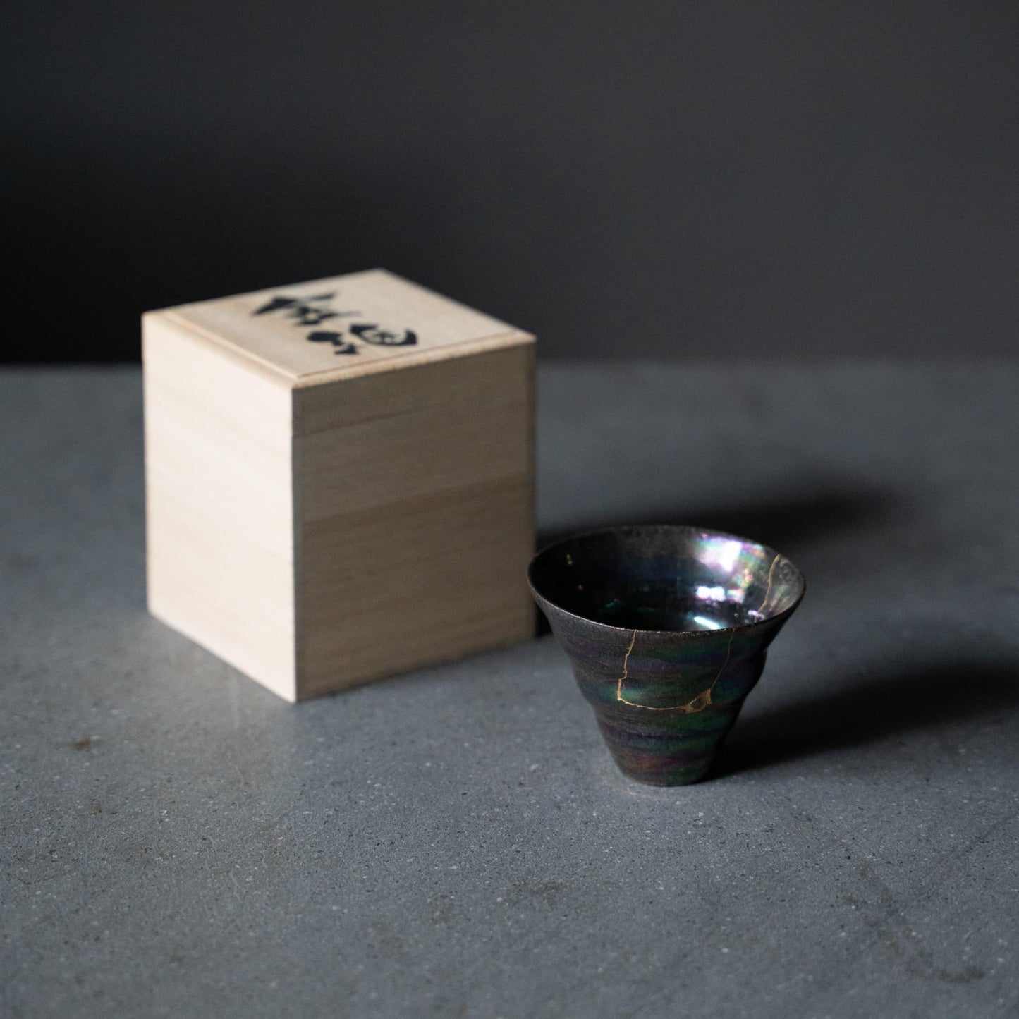 Kintsugi Sake Cup "Colored Clay Luster"and a paulownia wood box on gray table